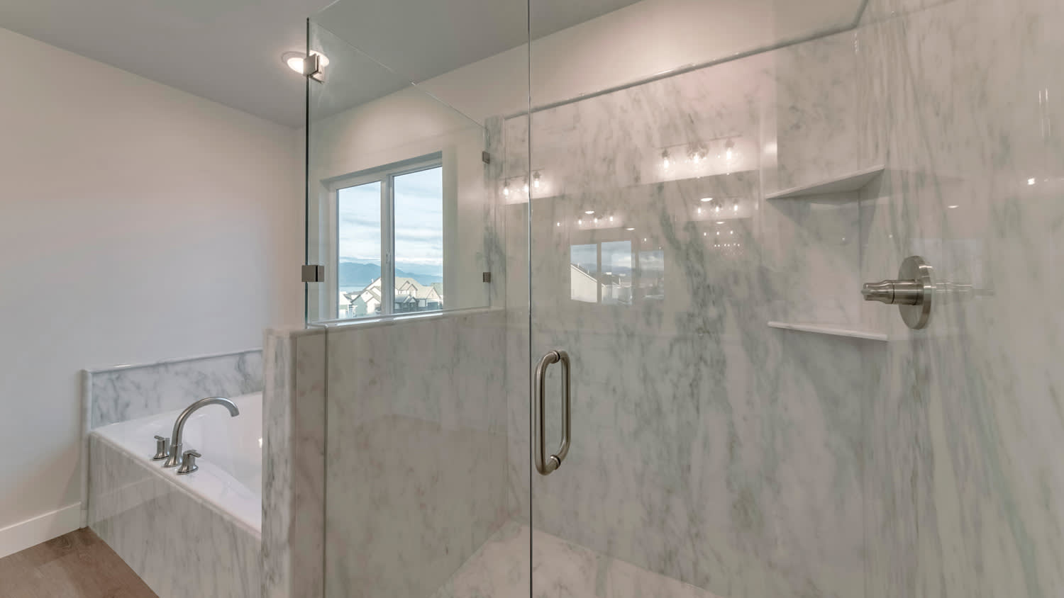 A bathroom with a frameless shower enclosure