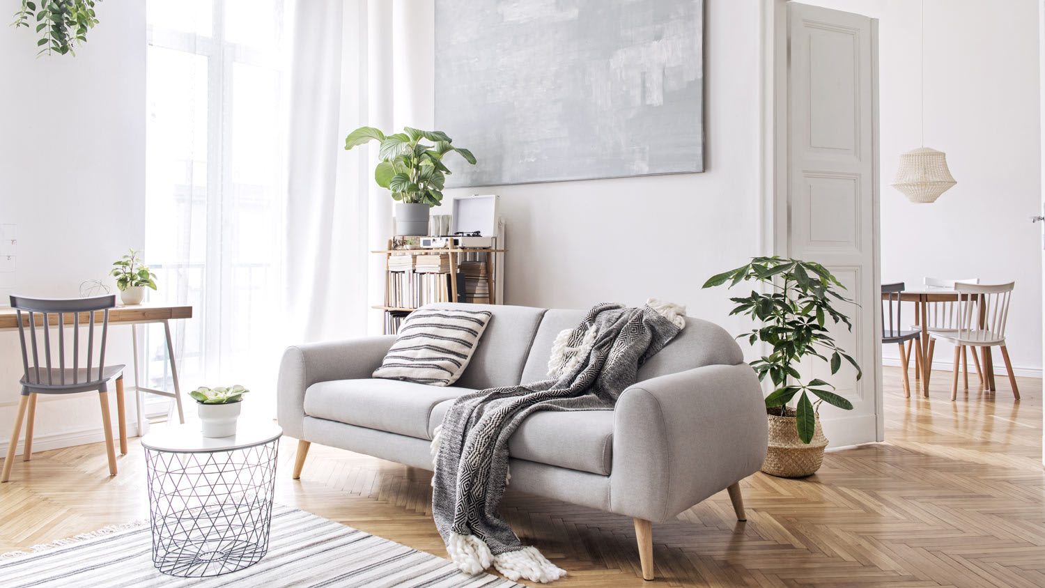 A living room with a dining area in the background