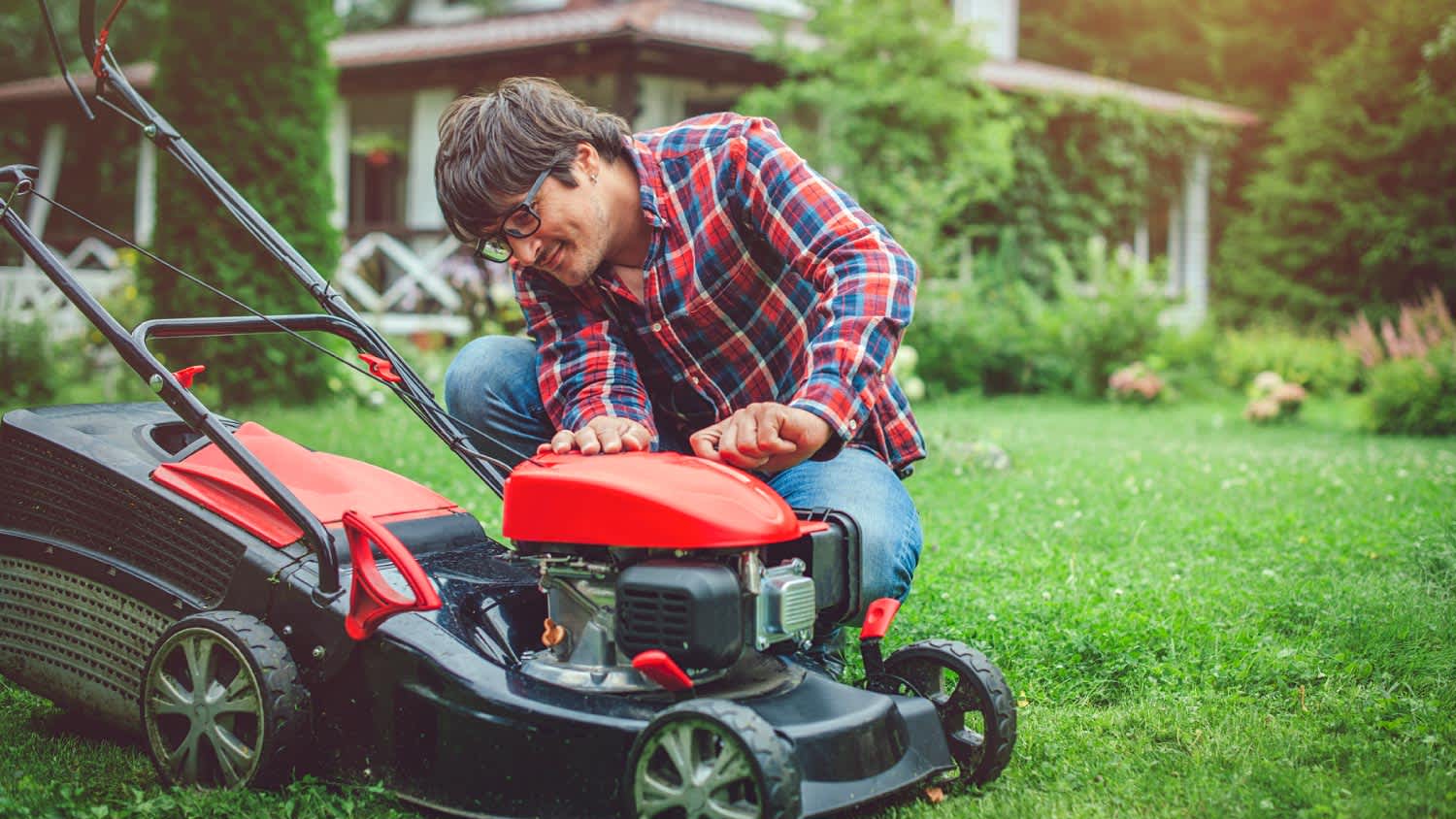 man doing a maintenance check on lawn mower