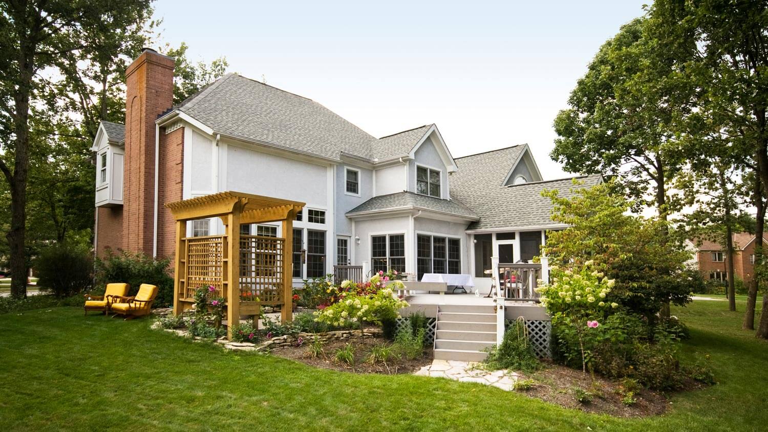 A backyard of a house with a wooden trellis