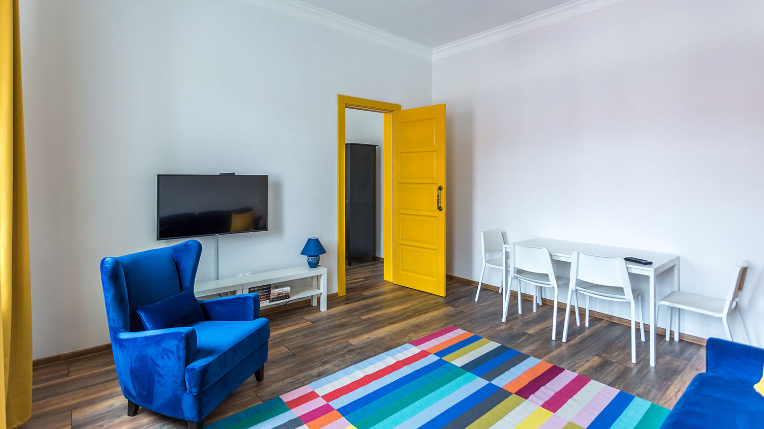 Living room with yellow door and blue sofa