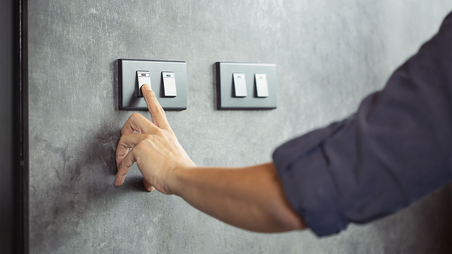 Closeup of a man turning light switch off