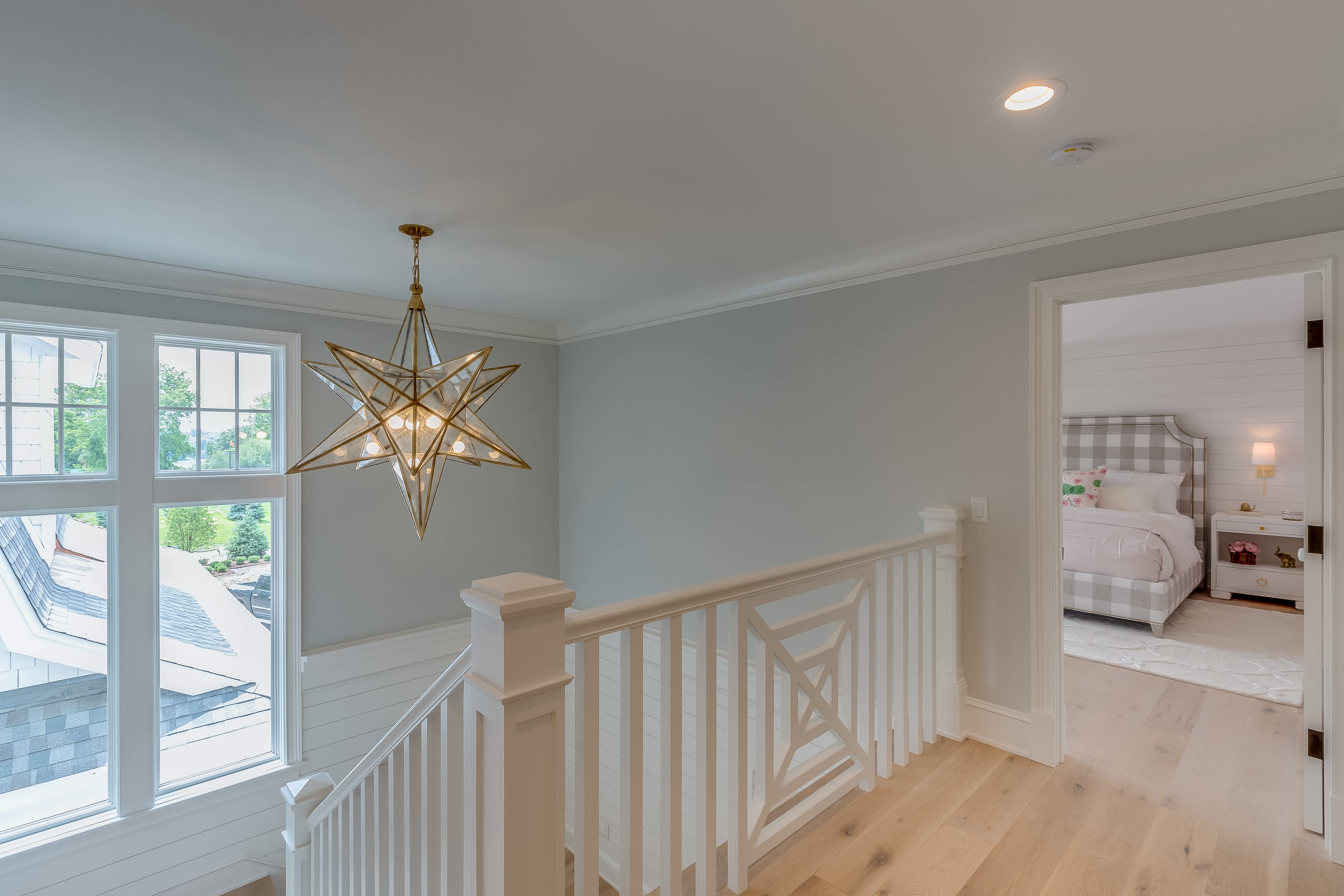 A starburst light pendant over an interior staircase
