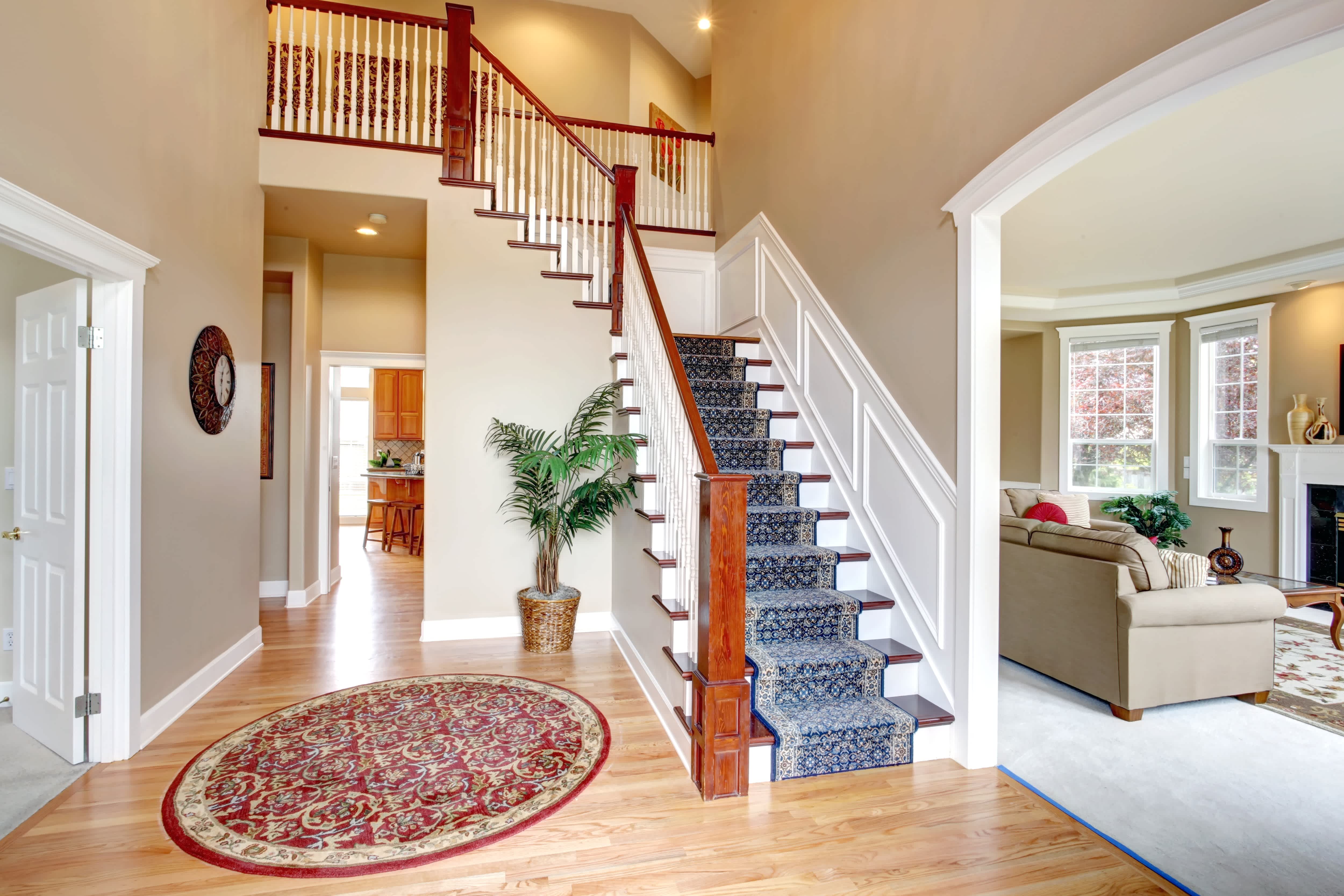 A large interior staircase with a decorative carpet running