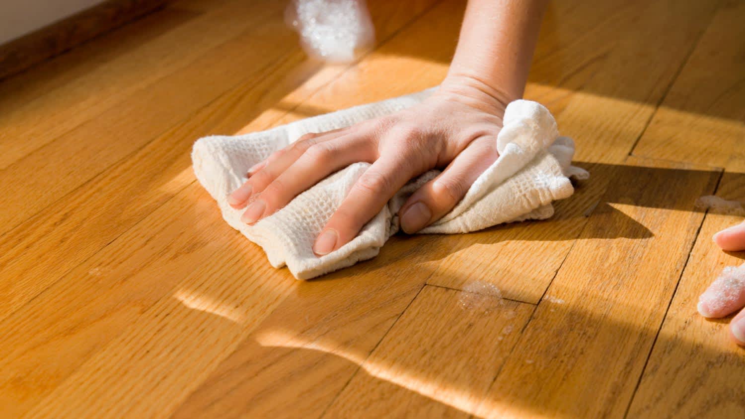 A woman cleaning wooden floor
