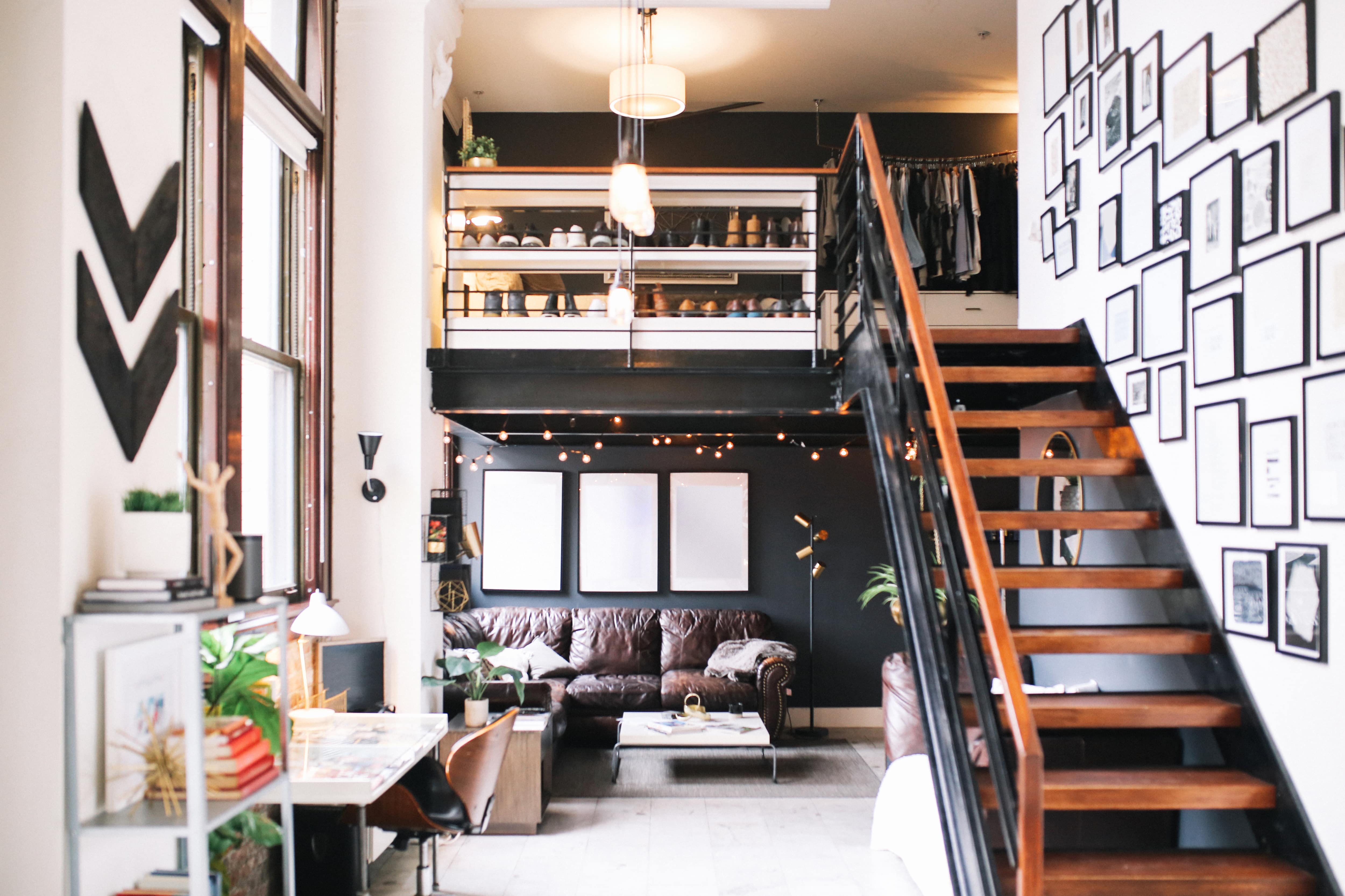 An industrial loft apartment with a gallery wall leading up the stairs