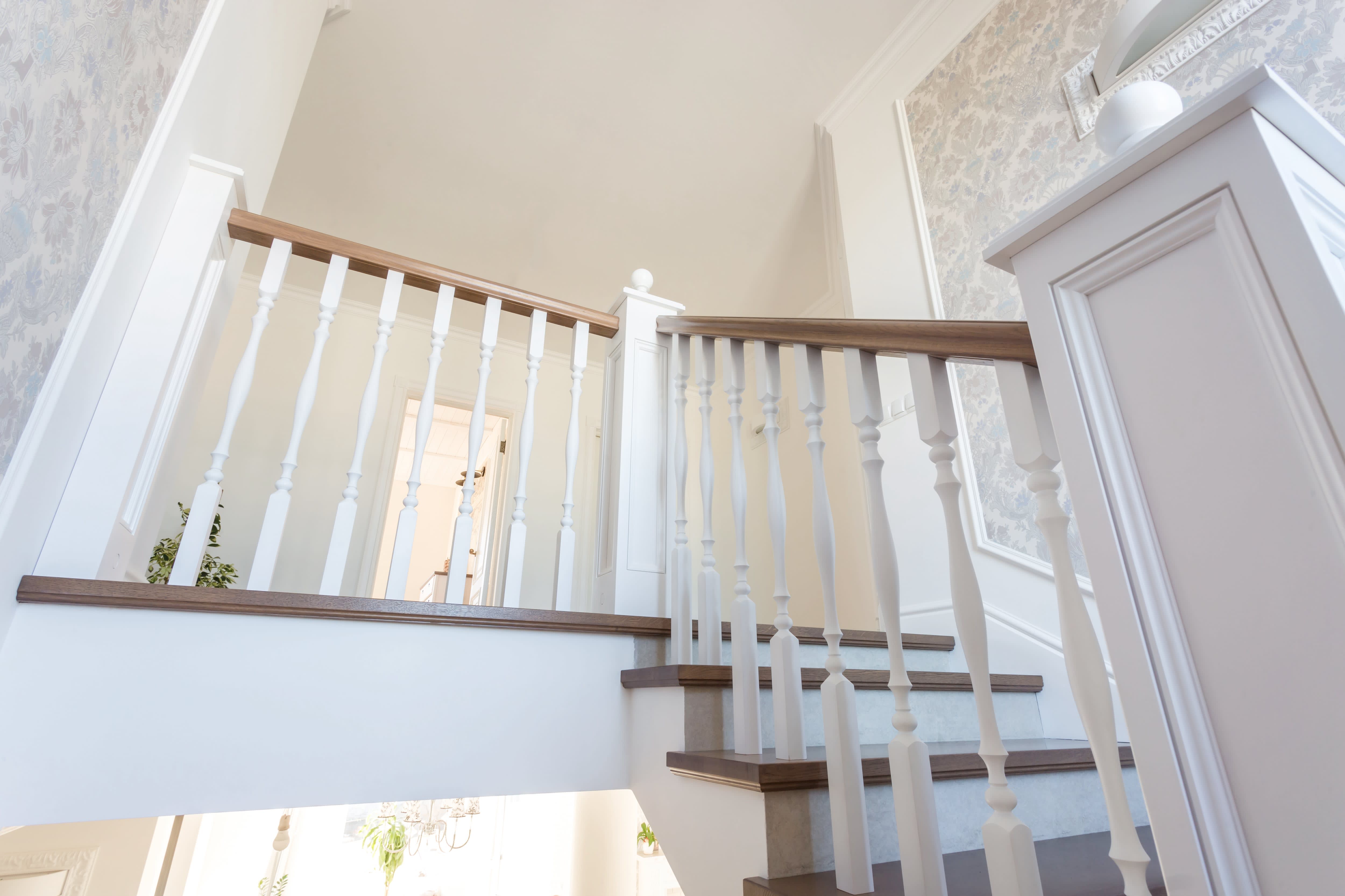 A bright interior staircase with vintage pattern wallpaper