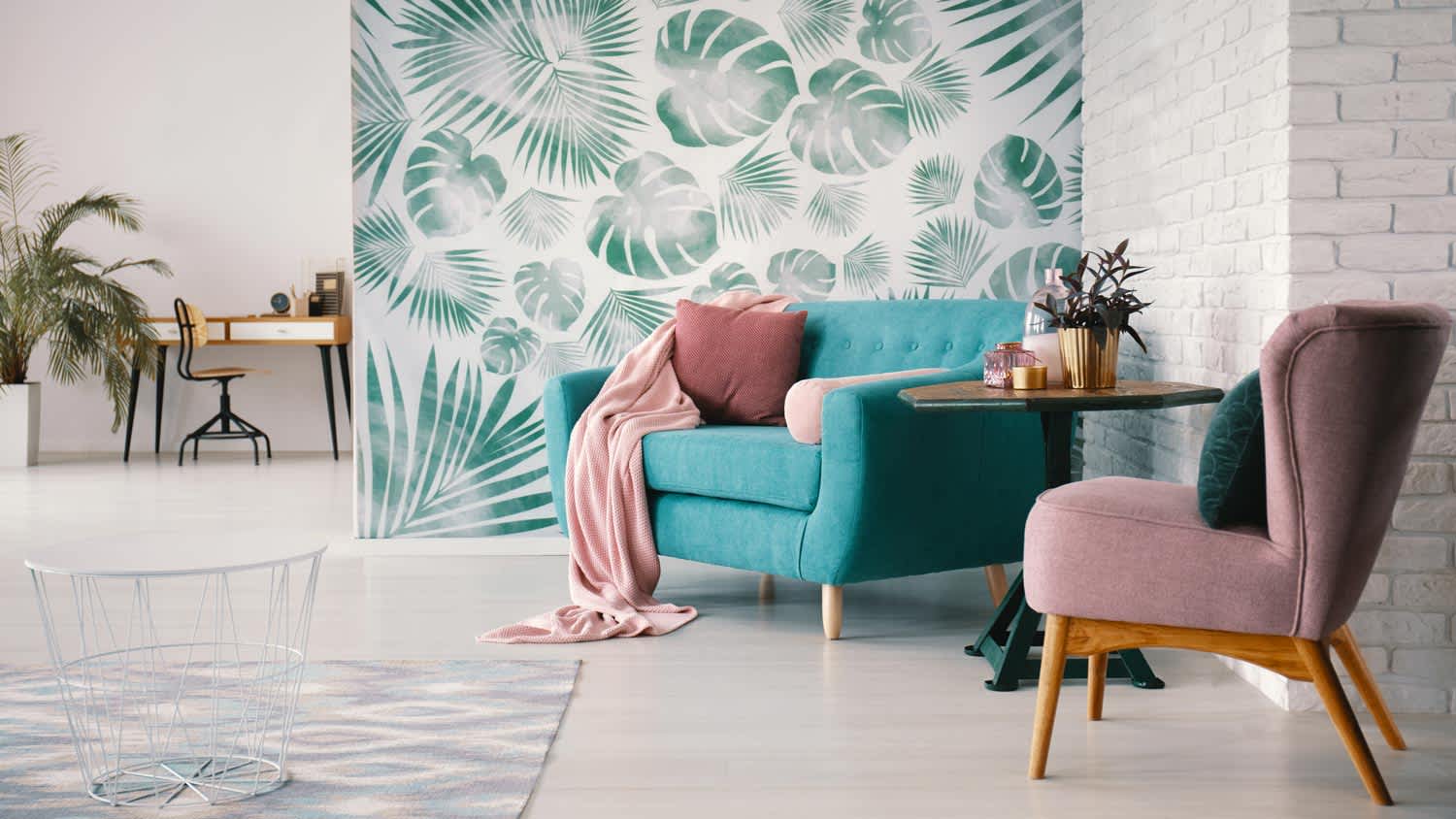 A sitting area with a green leaves wallpaper in the background