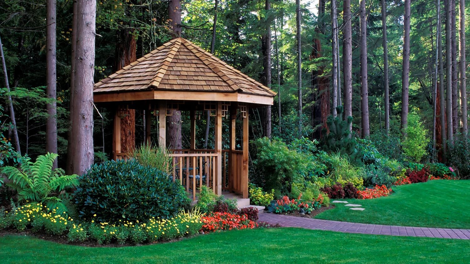 A wooden gazebo in the backyard of a house