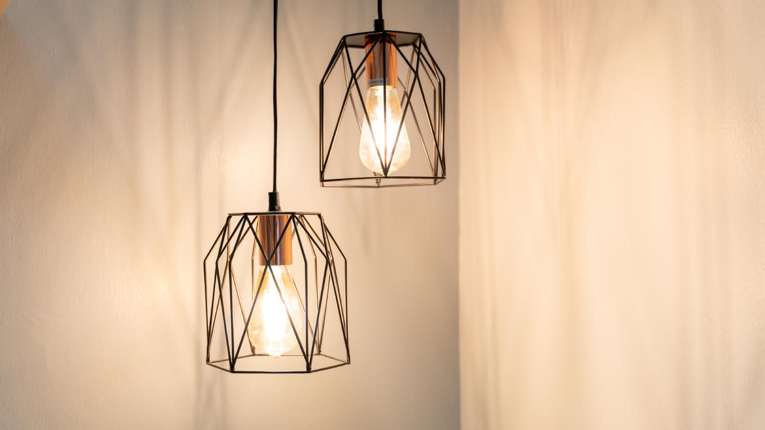Illuminated light bulb hanging on wall at home