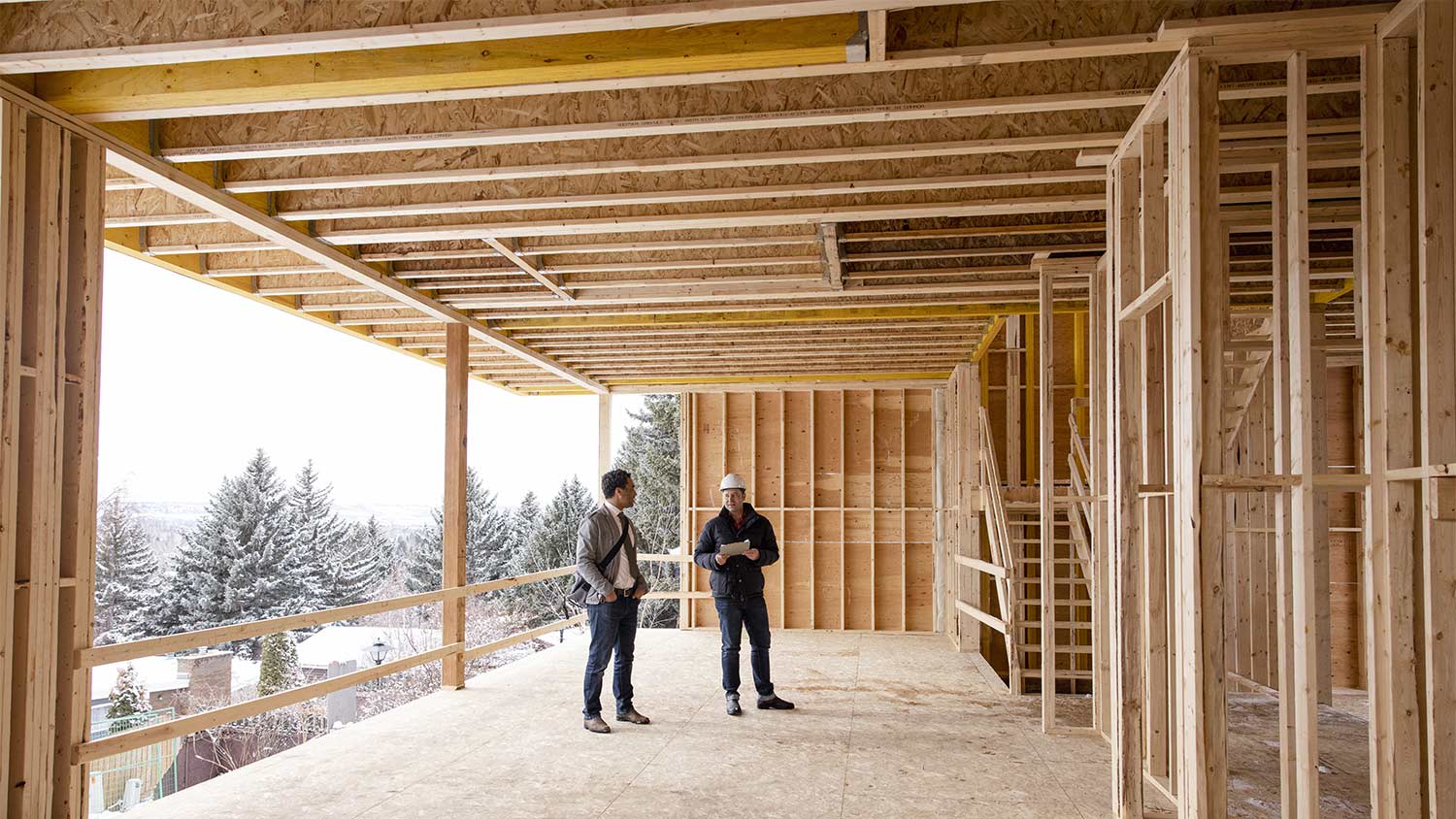 Men reviewing wood construction frame