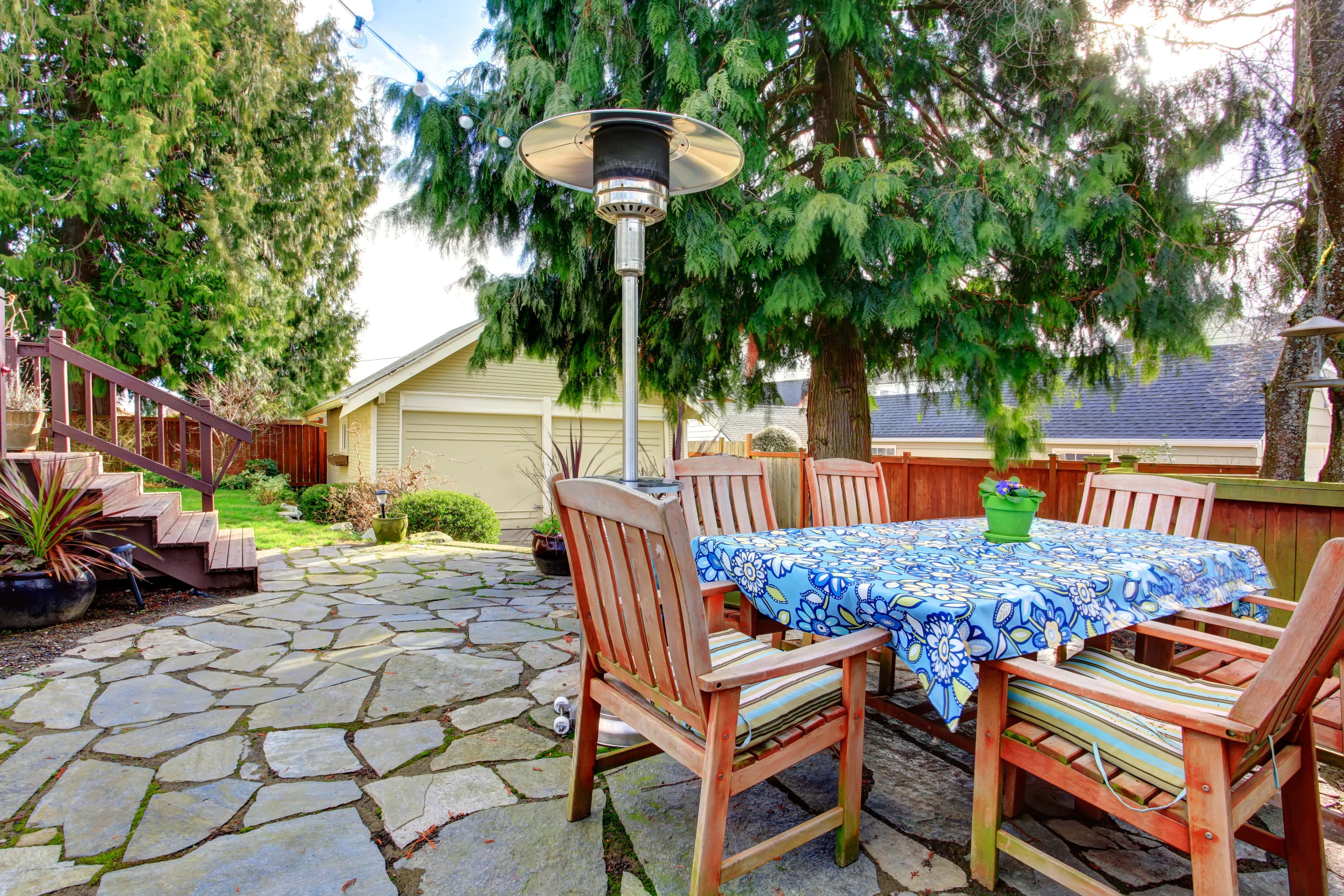 Stone patio with a table, chairs and heat lamp