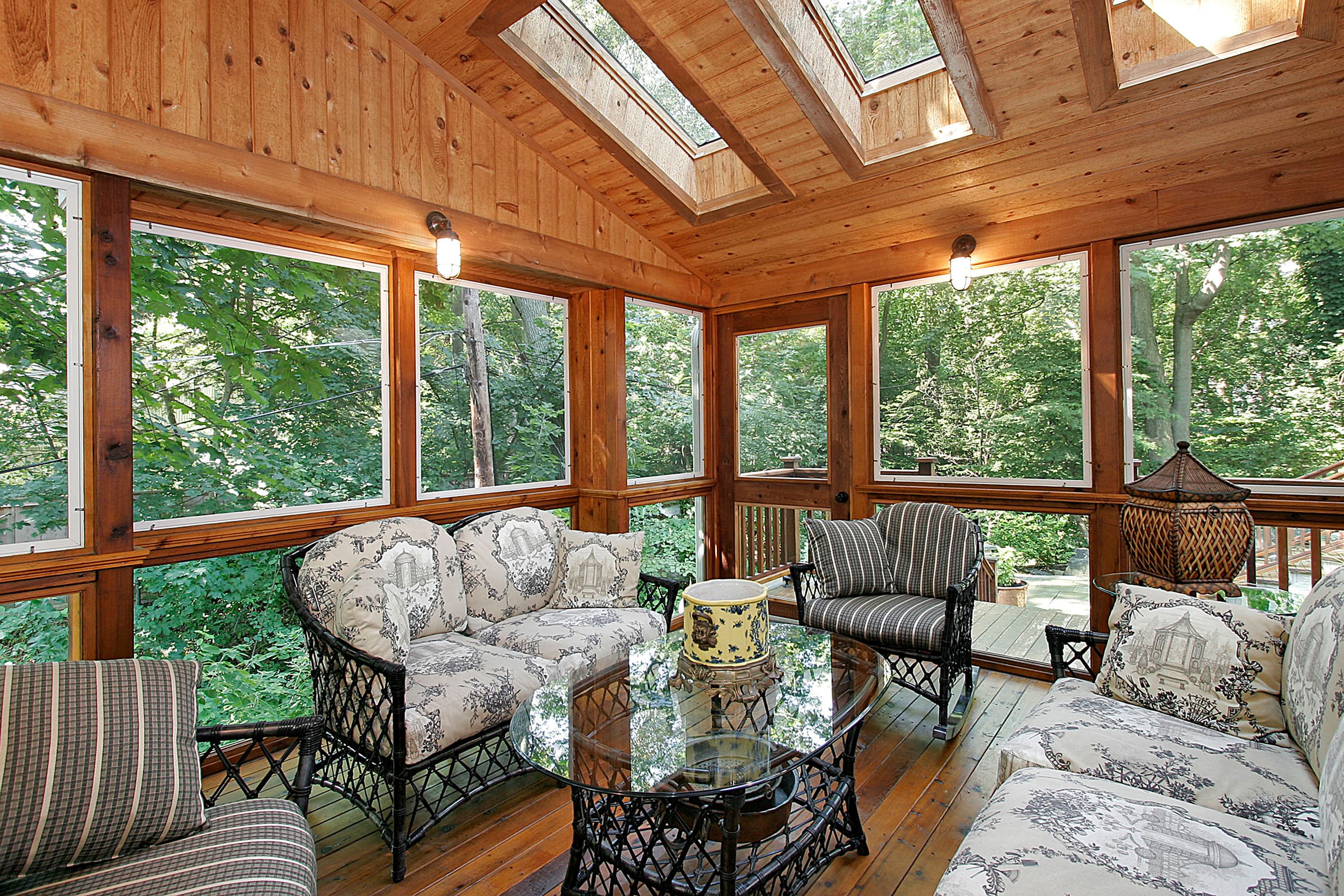 A wood paneled screened-in porch with skylights