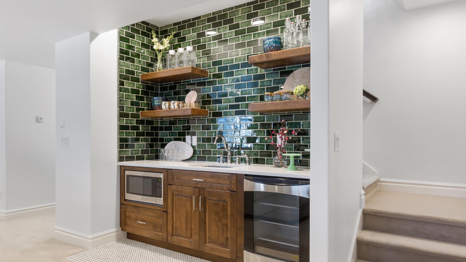 A basement kitchenette with beverage fridge and microwave