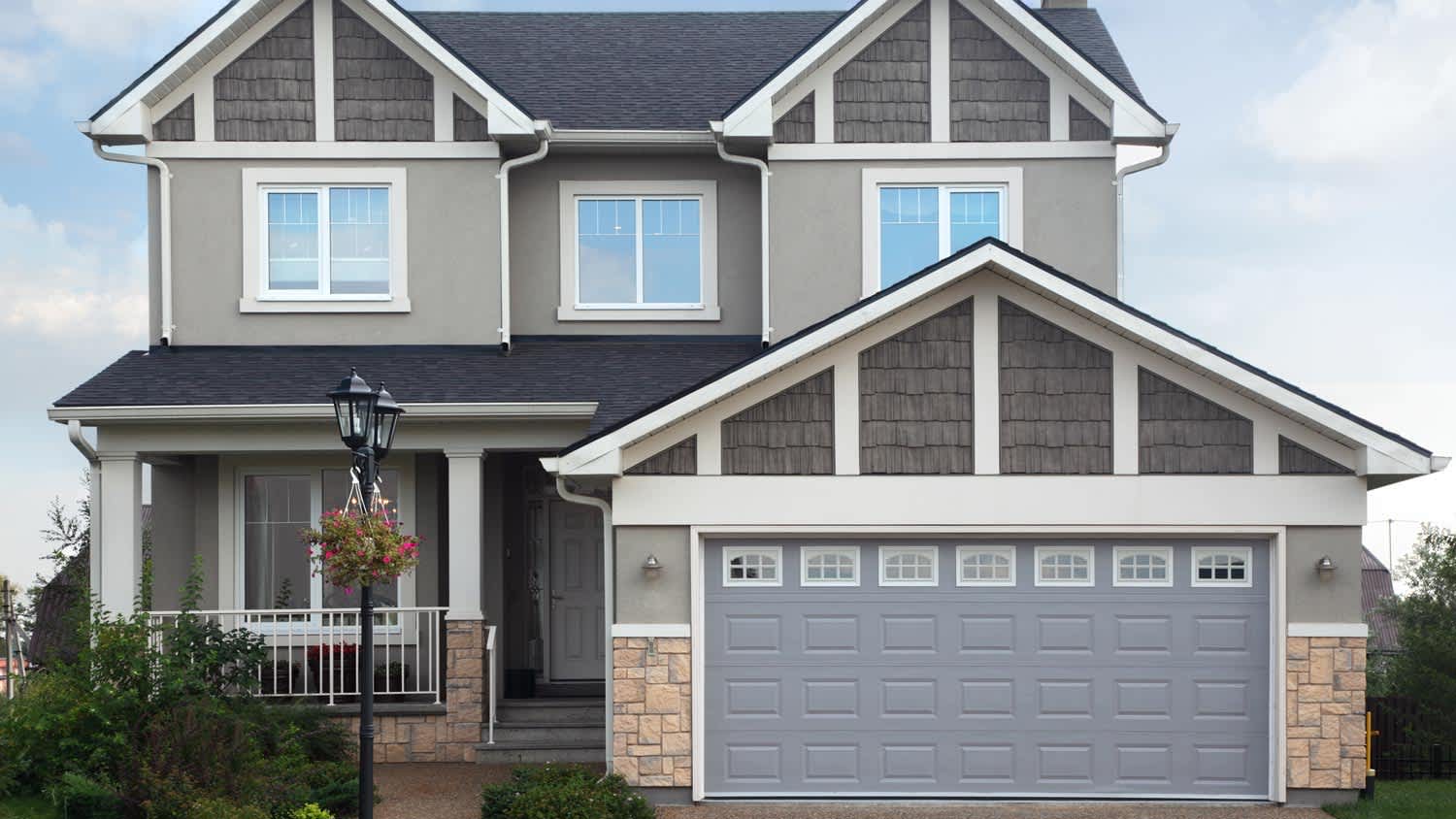 A two-story gray brick house with a garage