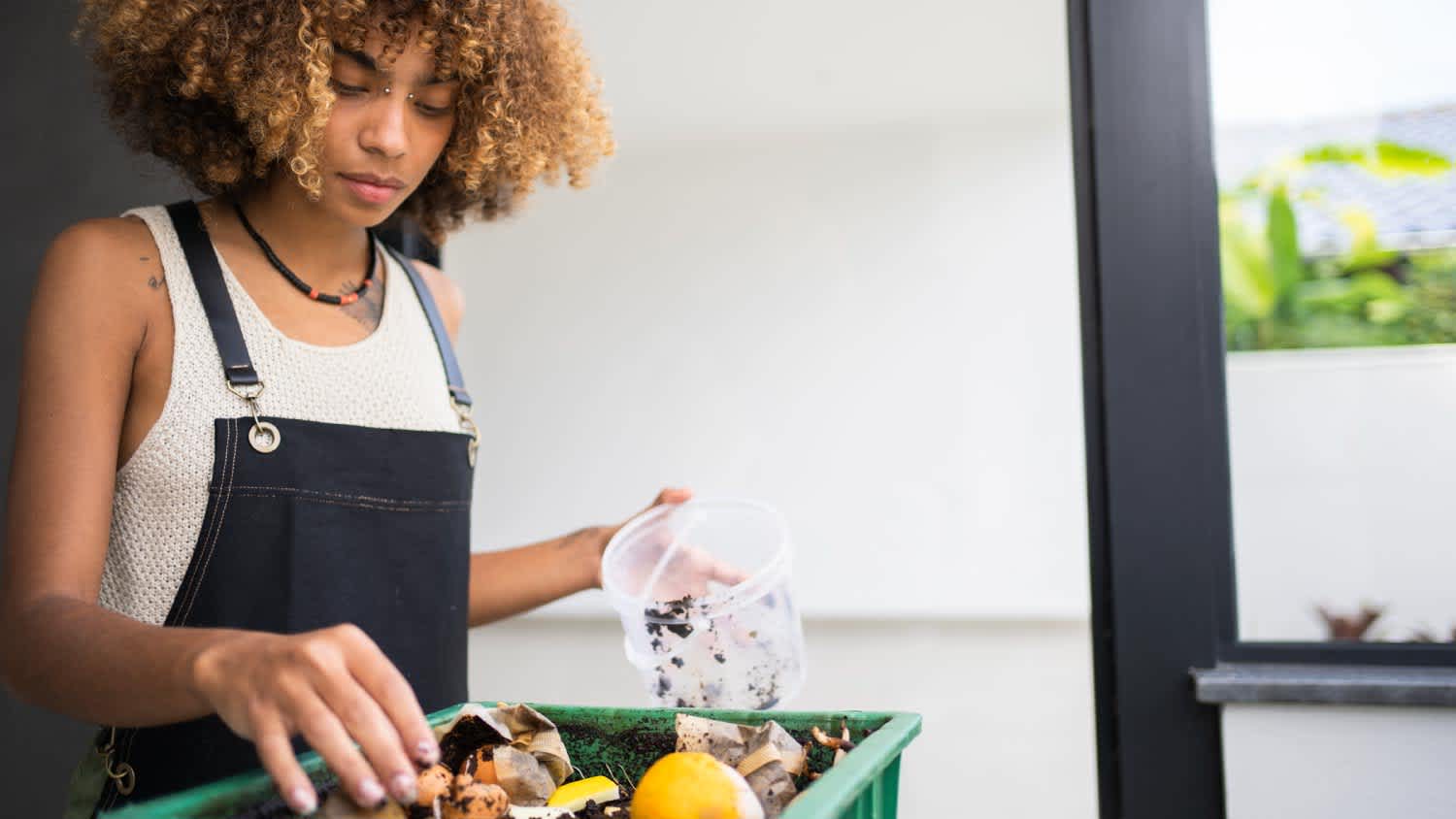 woman making compost from leftovers