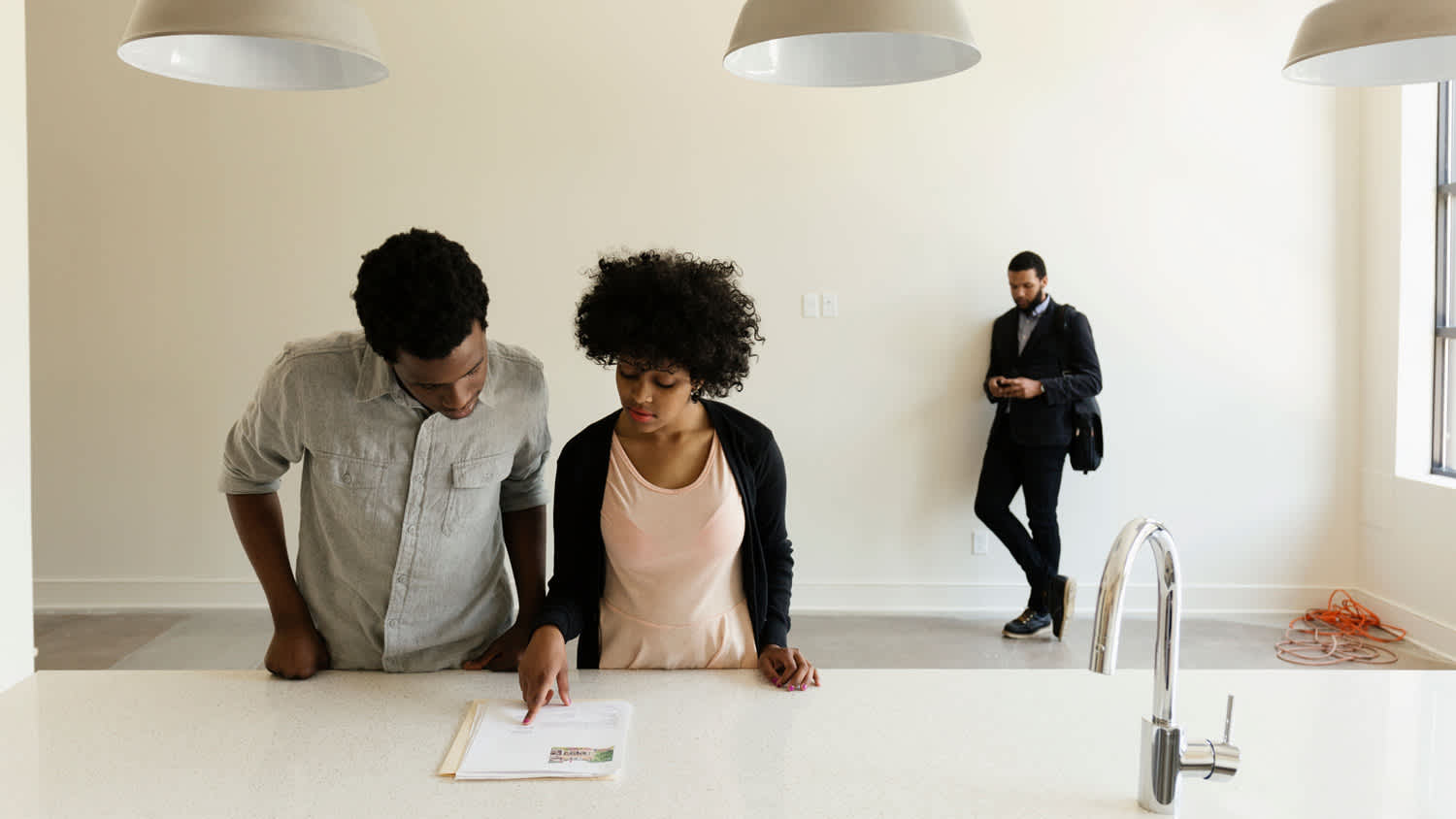 A young couple reading paperwork in a new house