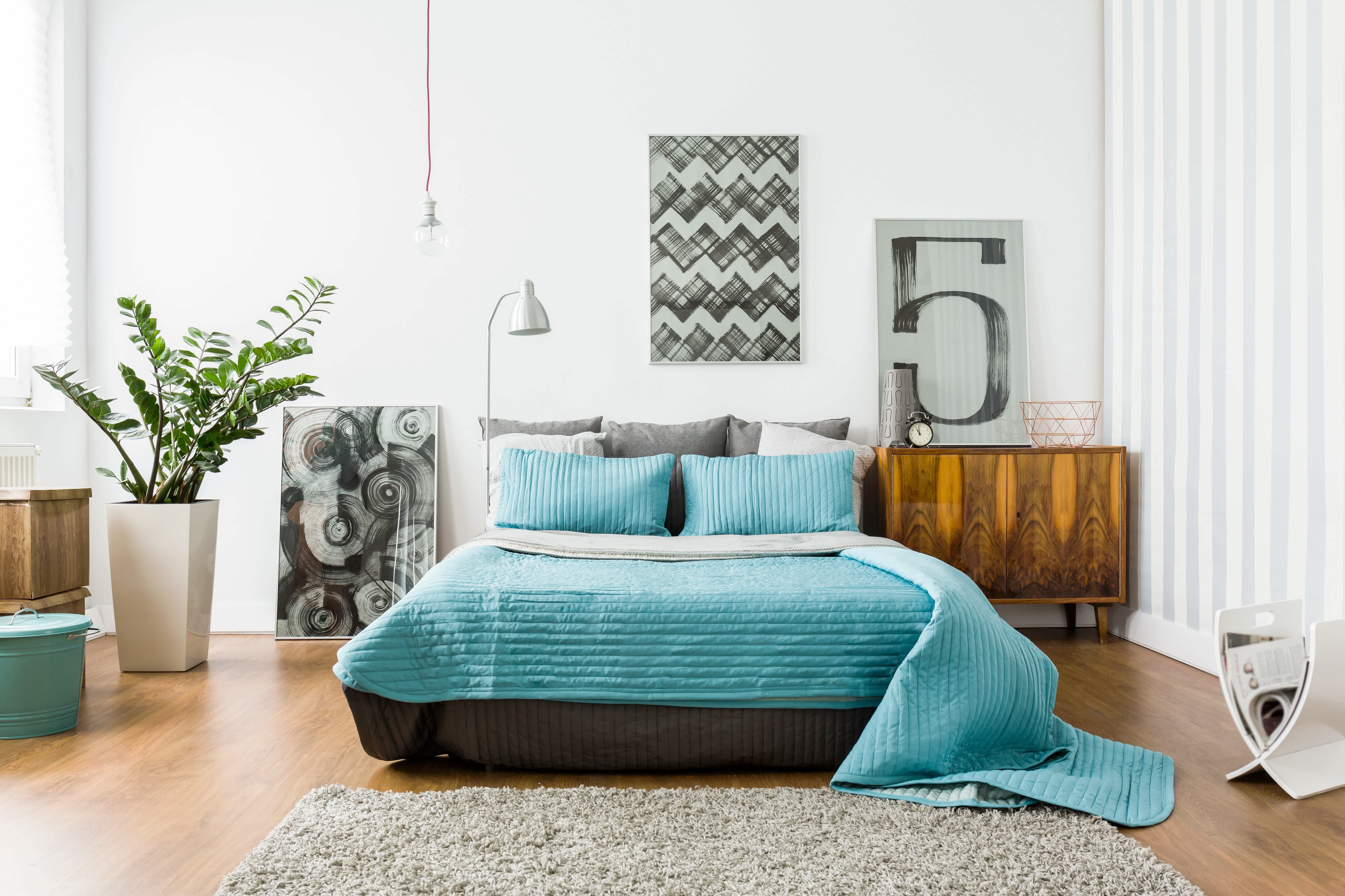 Neutral colored bedroom with a bed that has bright blue bedding