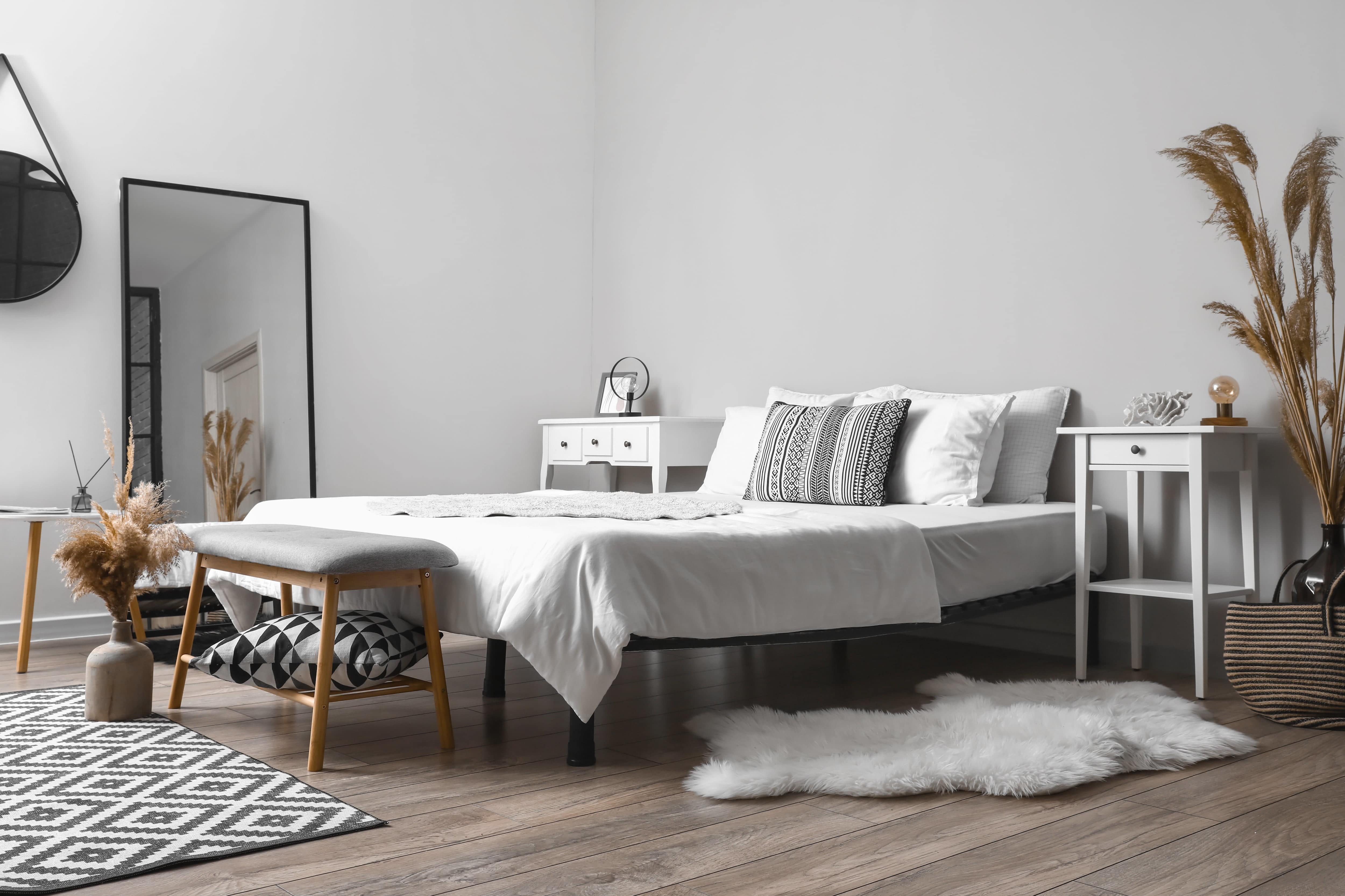 Bedroom with wooden floor and black and white patterned decor