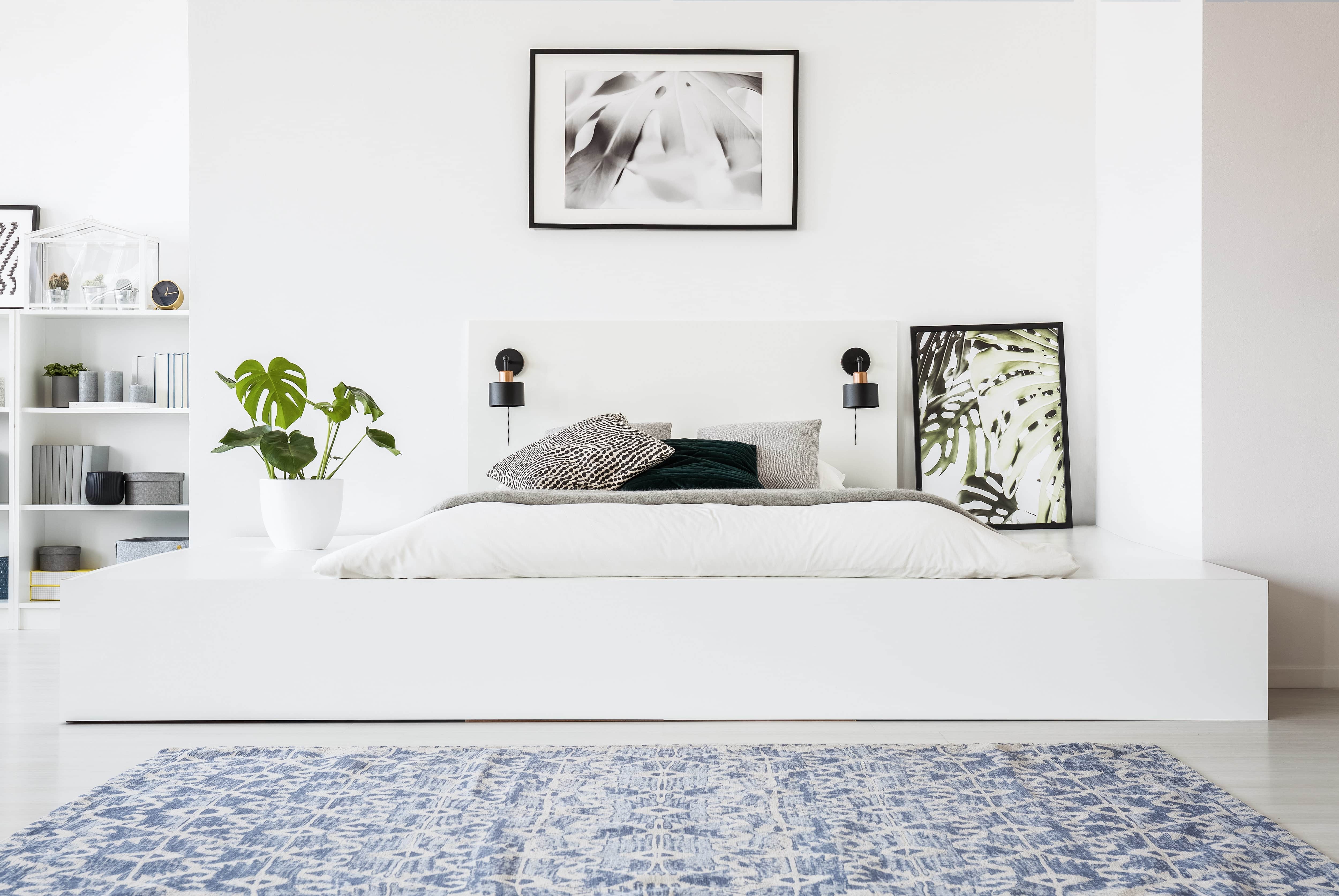 Bedroom with white and black decor and a large blue area rug