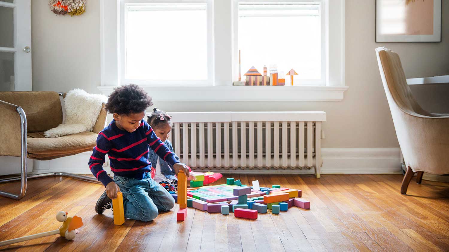 Kids playing with toys on hardwood floor