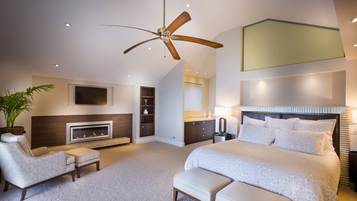 A ceiling fan in a large bedroom