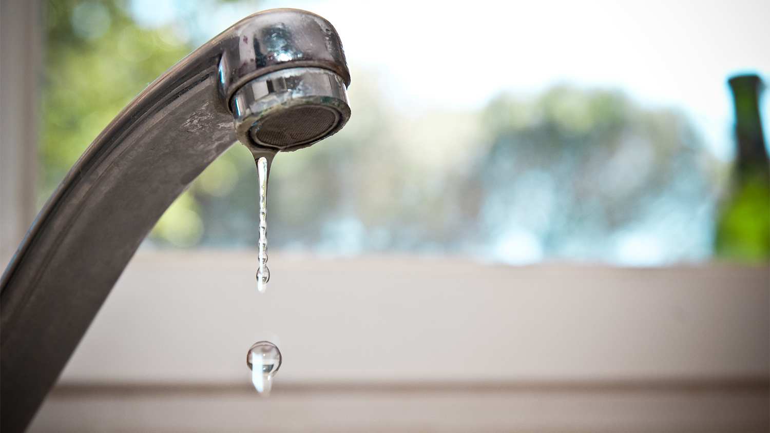 water dripping from leaky kitchen faucet