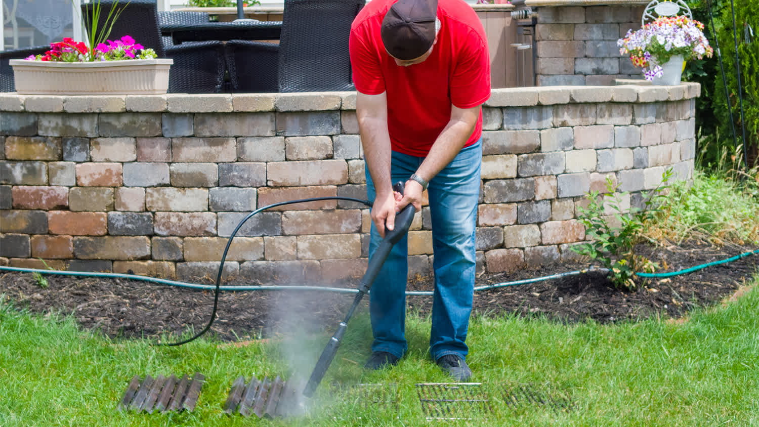 man using pressure washer to clean grill