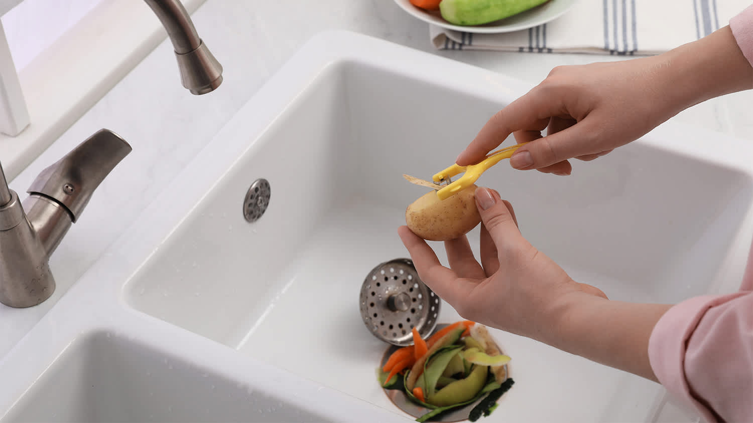 woman peeling vegetables over garbage disposal