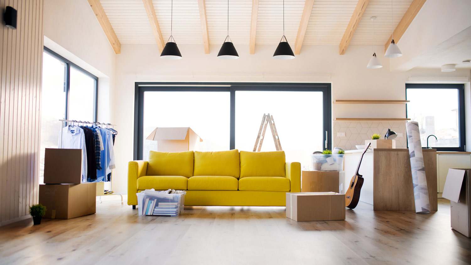 Moving boxes and a yellow sofa in a living room