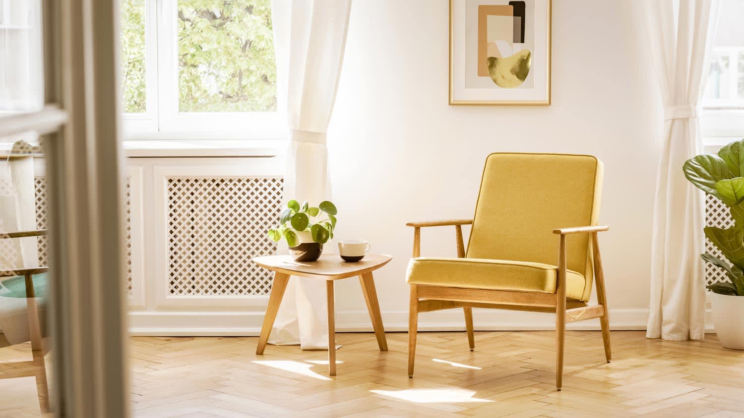 A yellow armchair in a room with hardwood floors