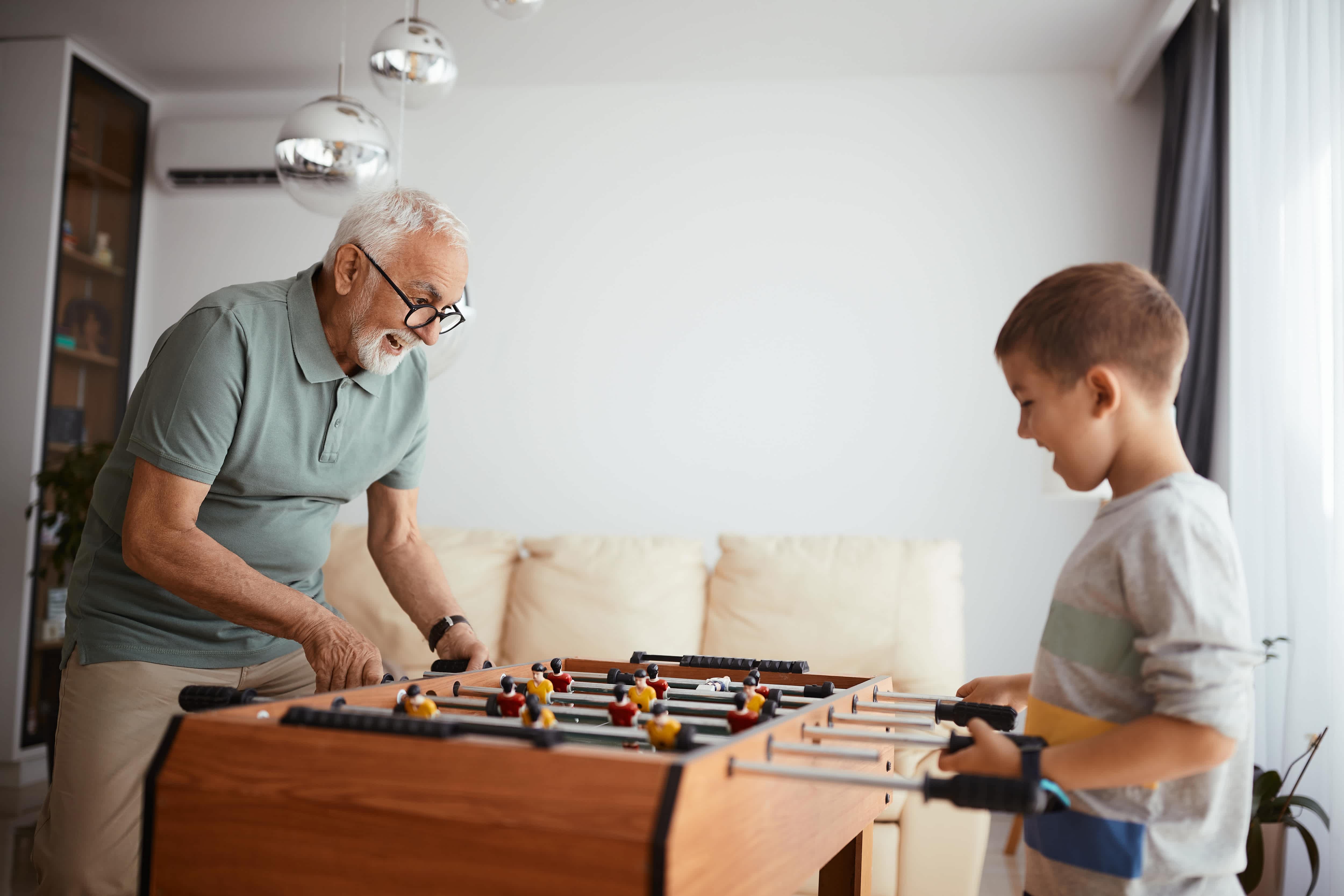 Grandfather and grandson playing foosball