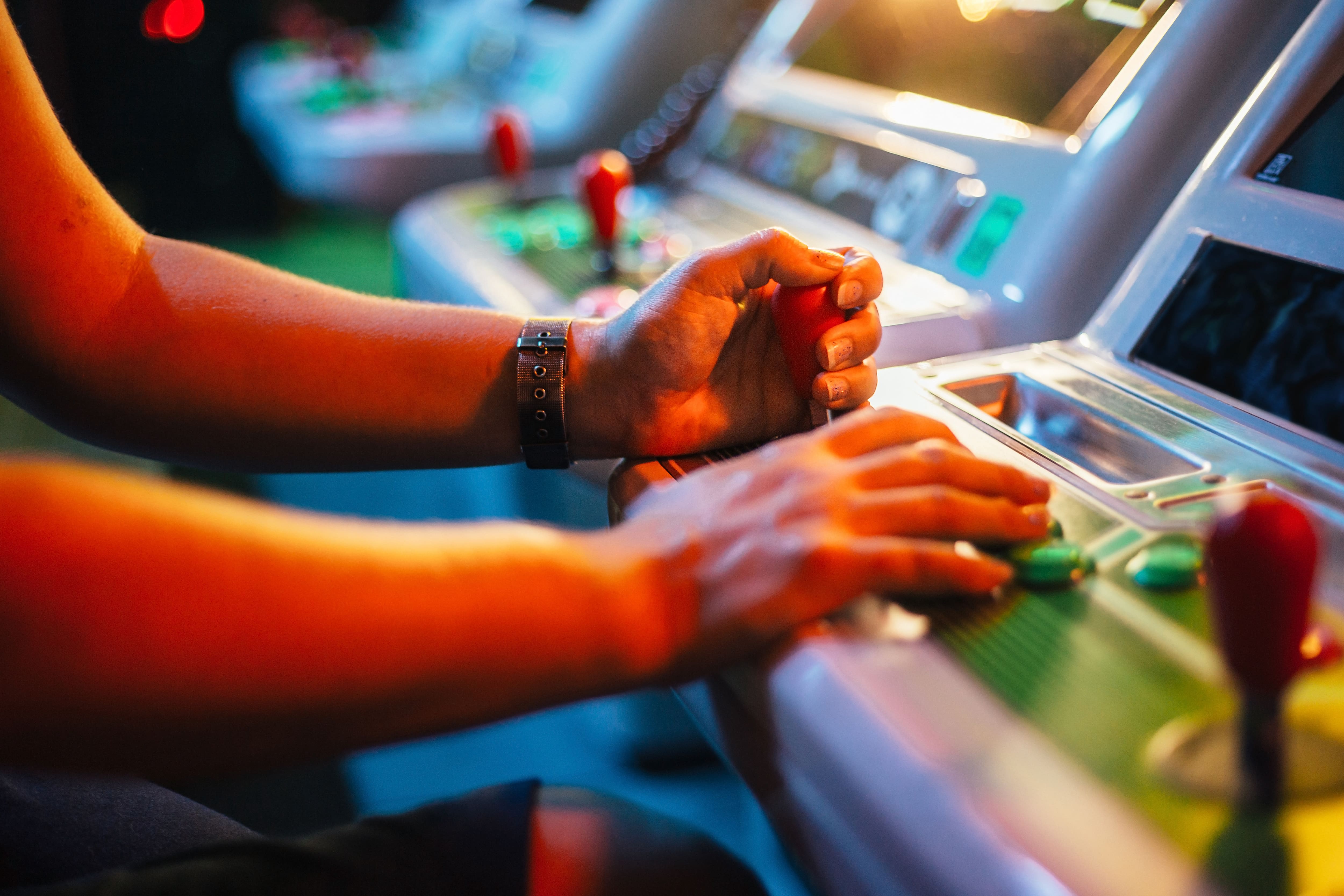 A person playing a vintage arcade game in a dark room