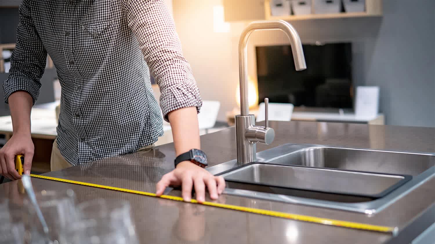 Man measures countertop with measuring tape