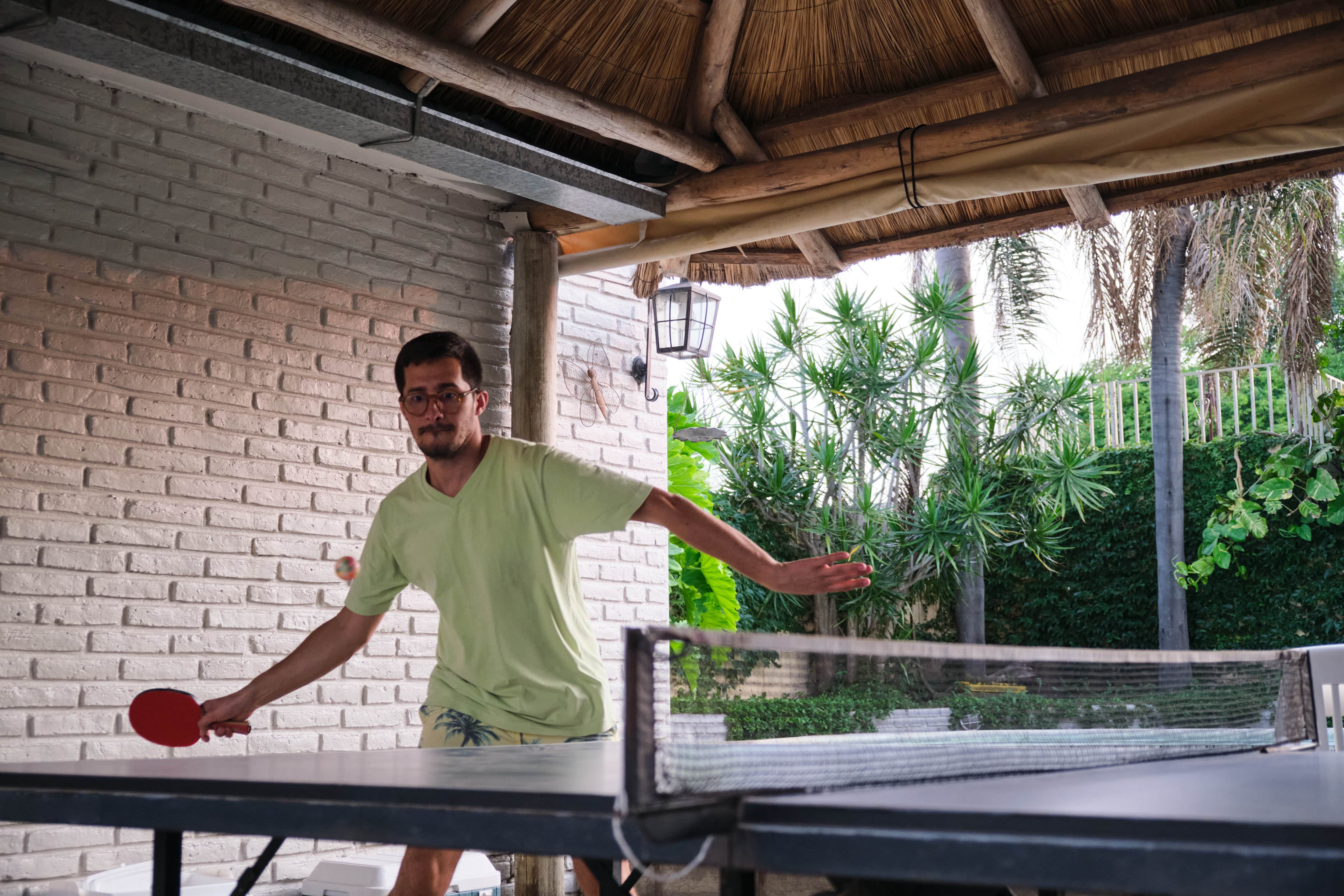 Man playing ping pong outdoors