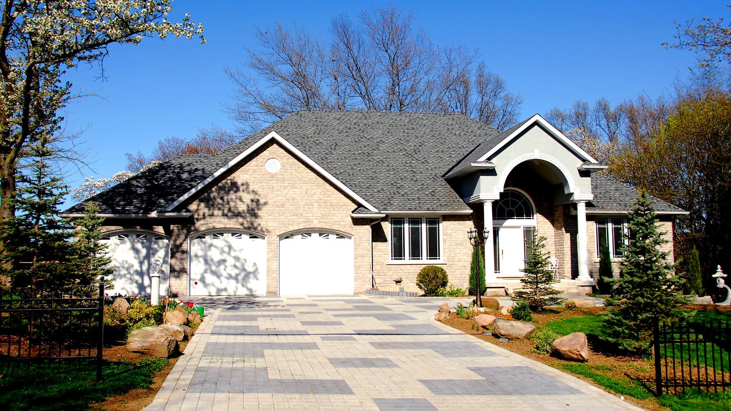 A paved driveway leading to a closed double door garage