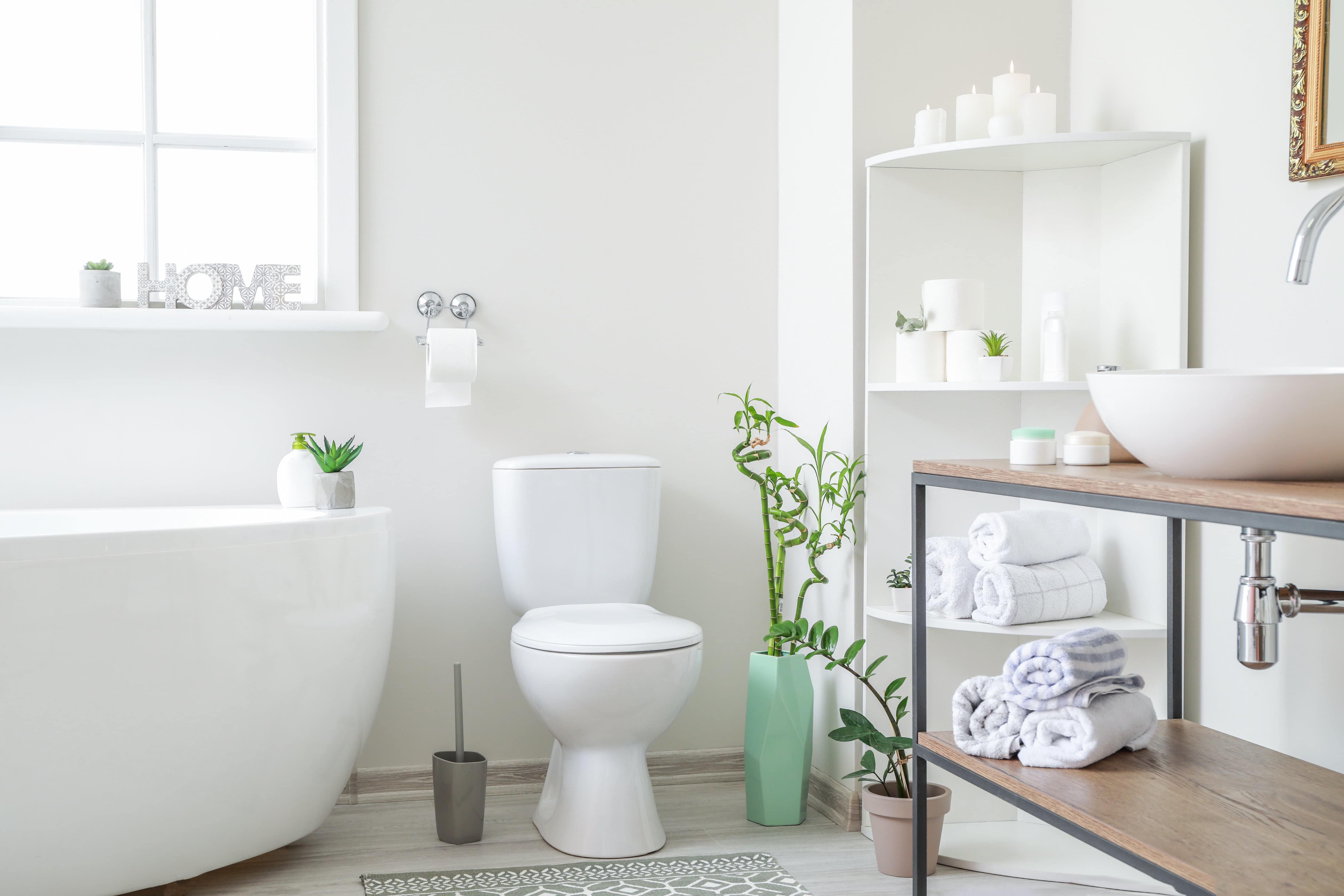 All-white bathroom with colorful vases