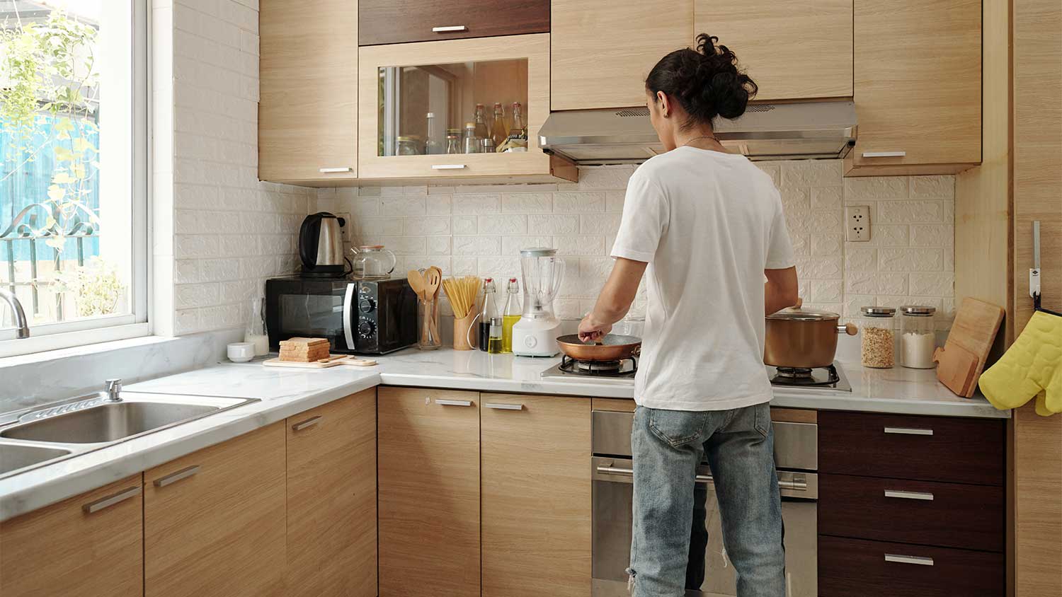 Young man in front of the stove cooking a meal