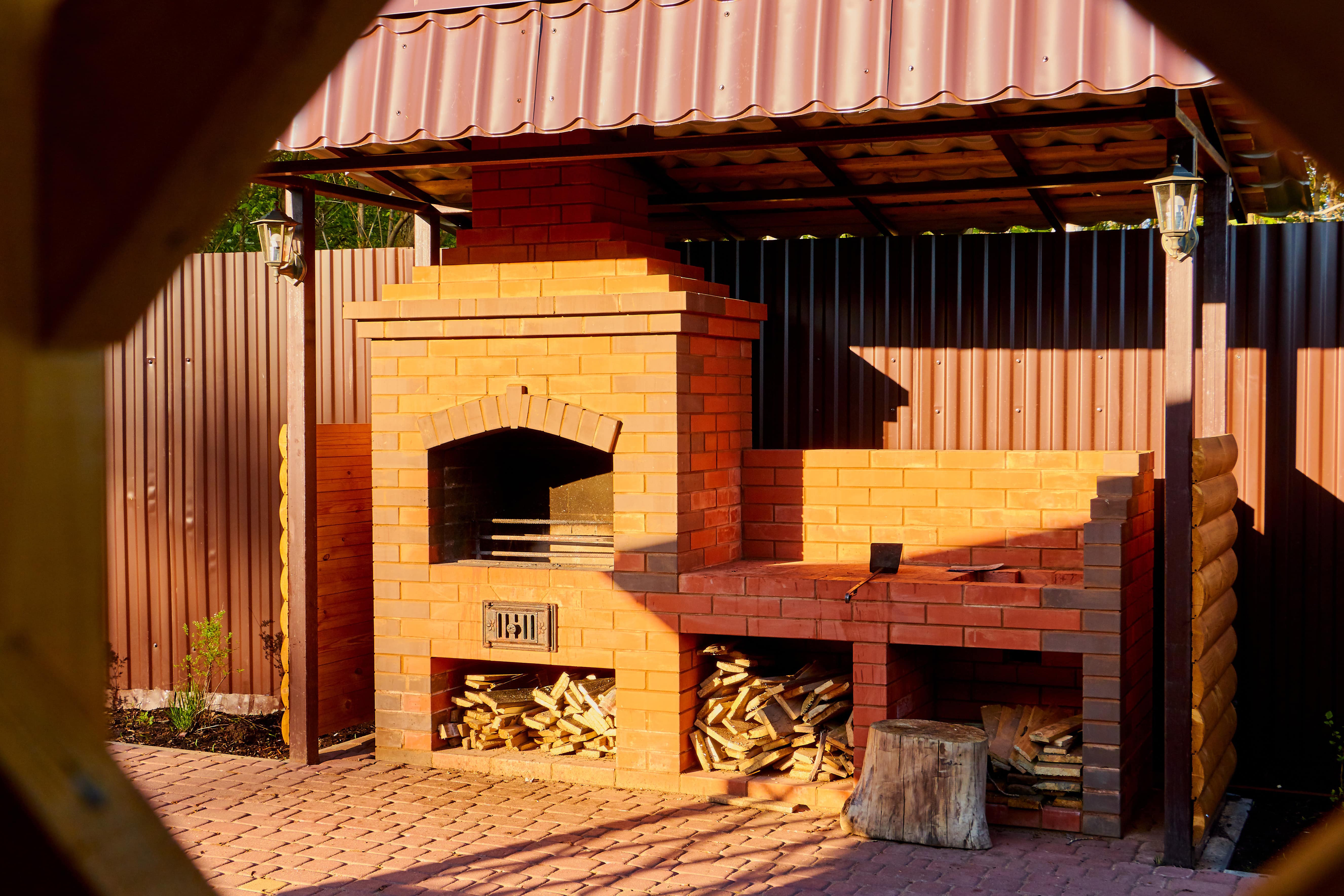 Pergola with awning housing an outdoor BBQ grill