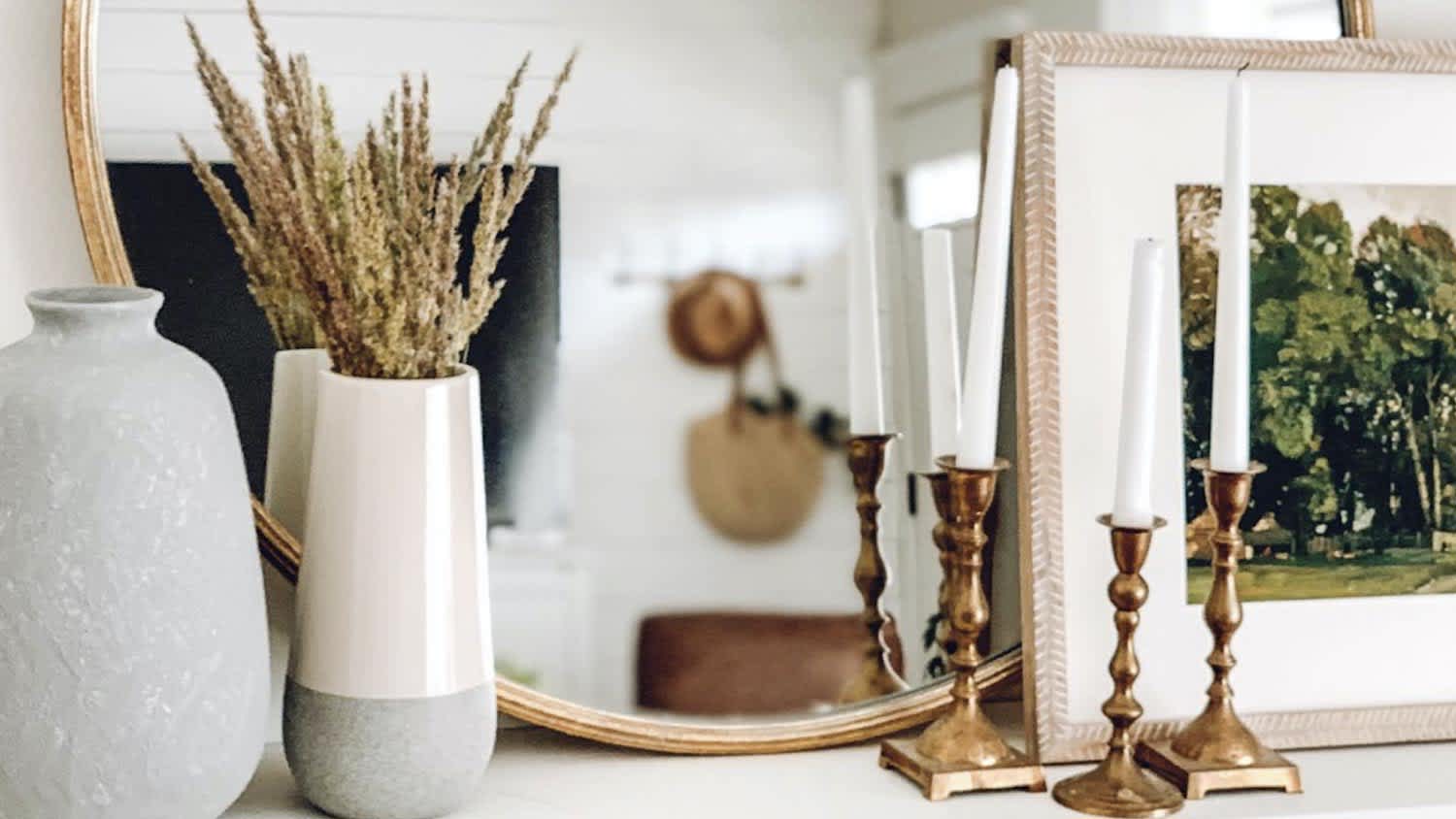 Living room with flowers and candles round gold mirror