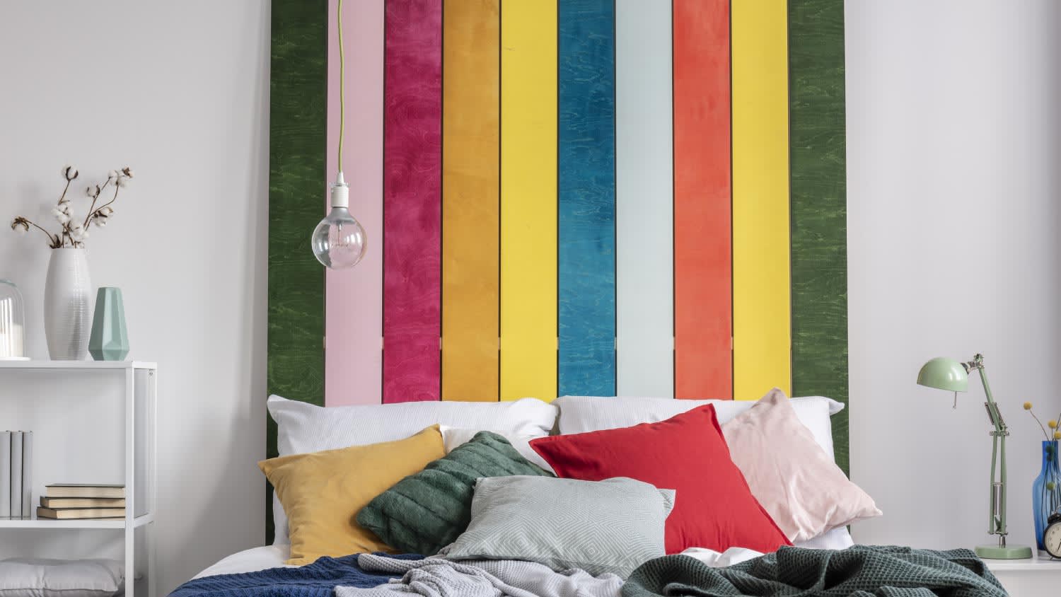 A colorful bed with cushions and blankets