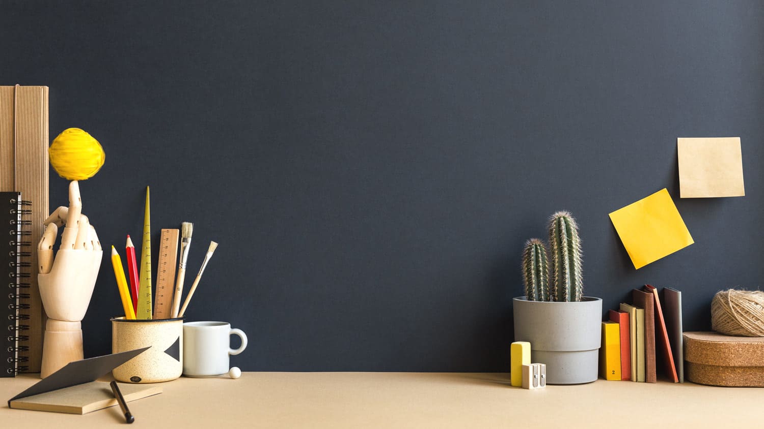 A creative desk with office supplies and a plant