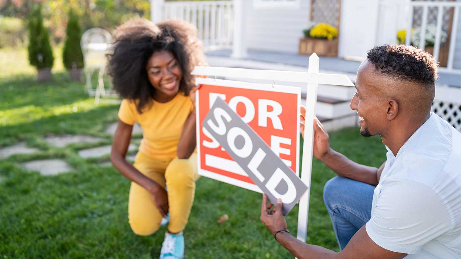Family in yard with for sale sign