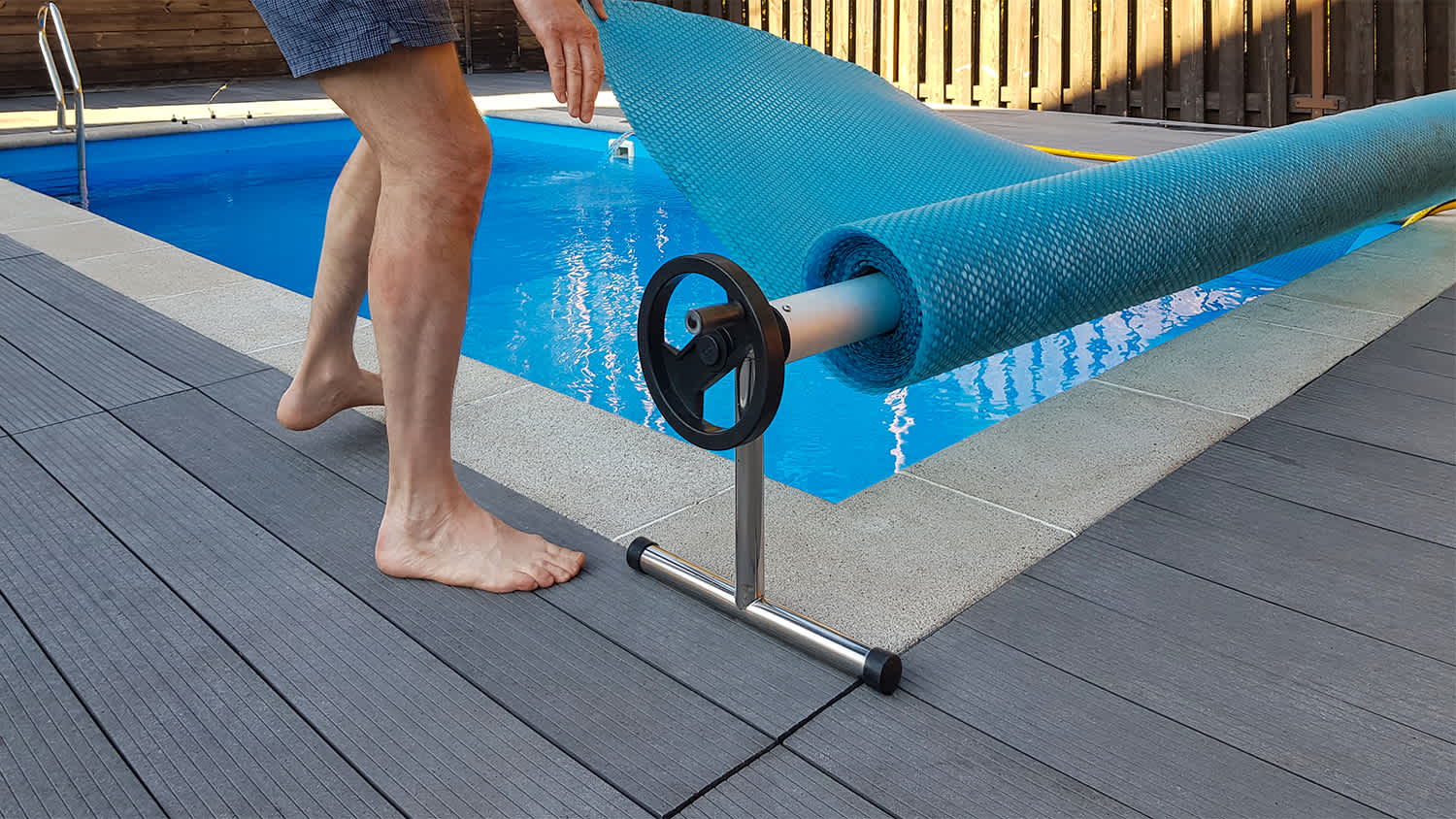 man covering swimming pool in yard