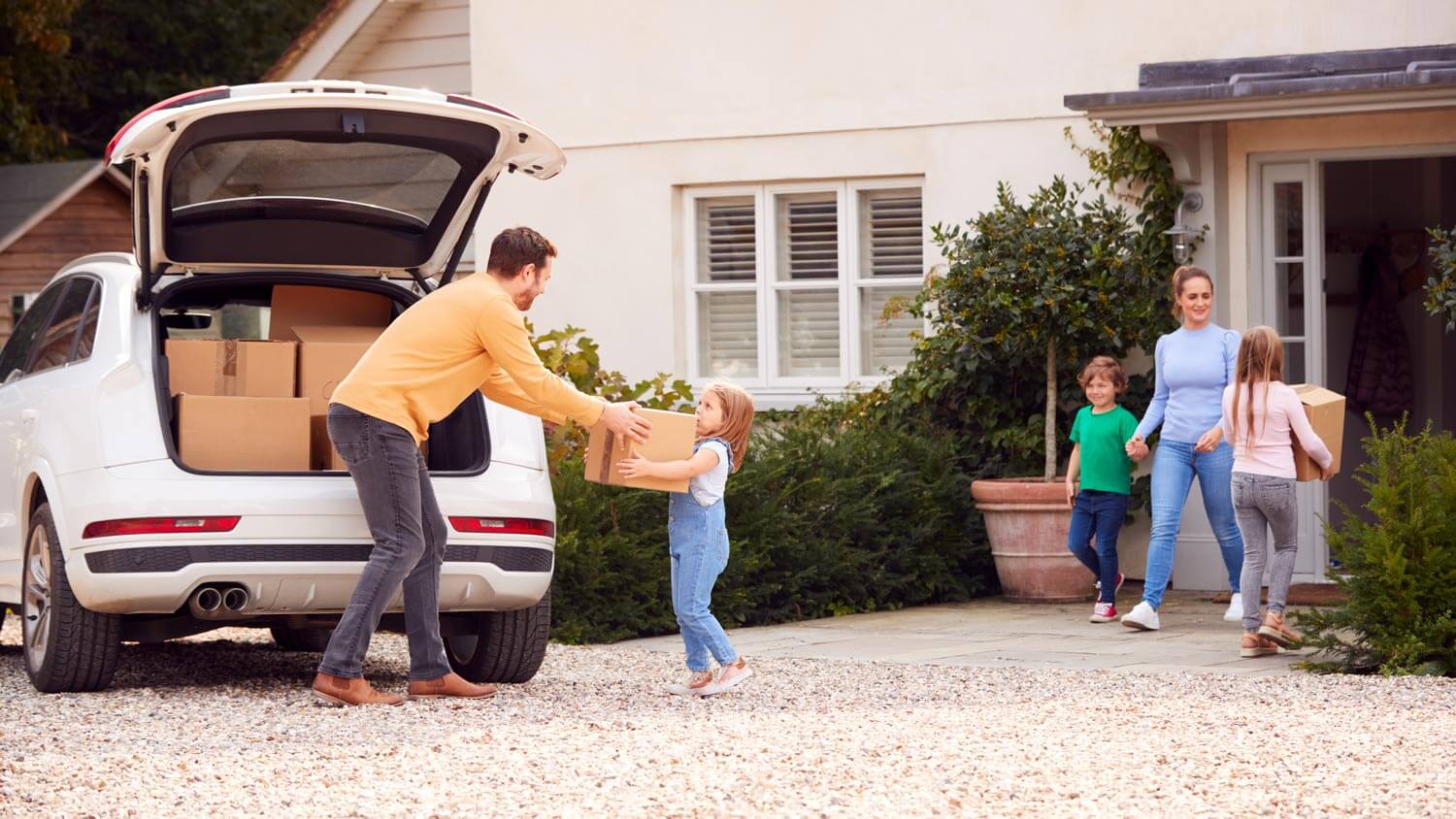 A family unloading boxes from the car on moving day