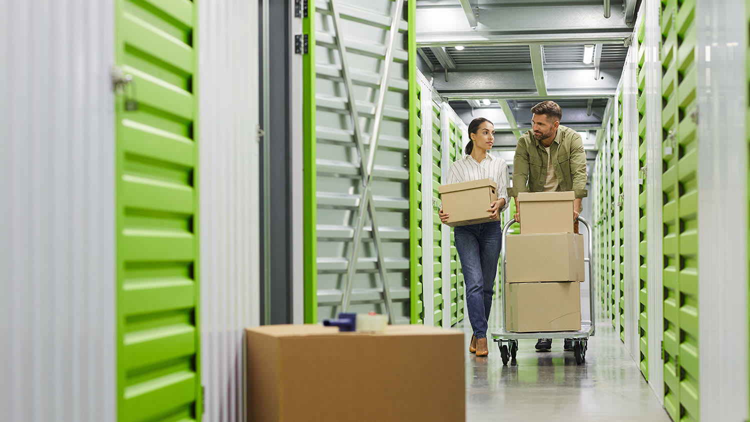 Couple holding boxes in storage unit