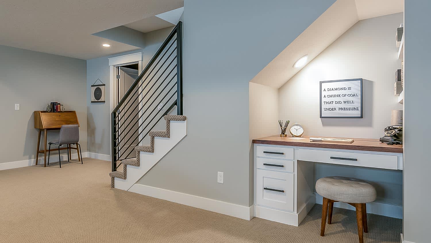 Basement rec room with home office desk underneath the stairs