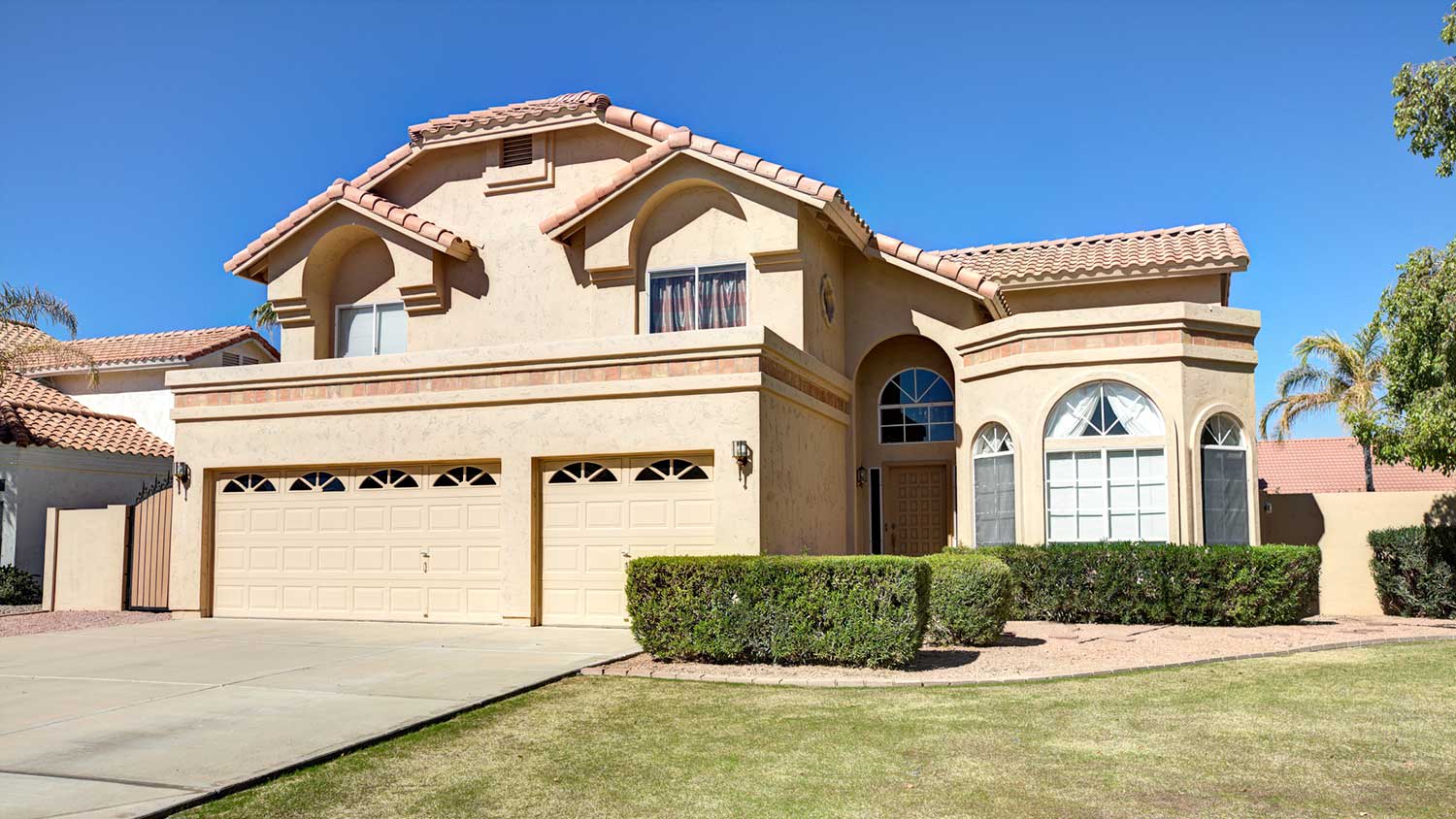 Two story stucco home with large garage