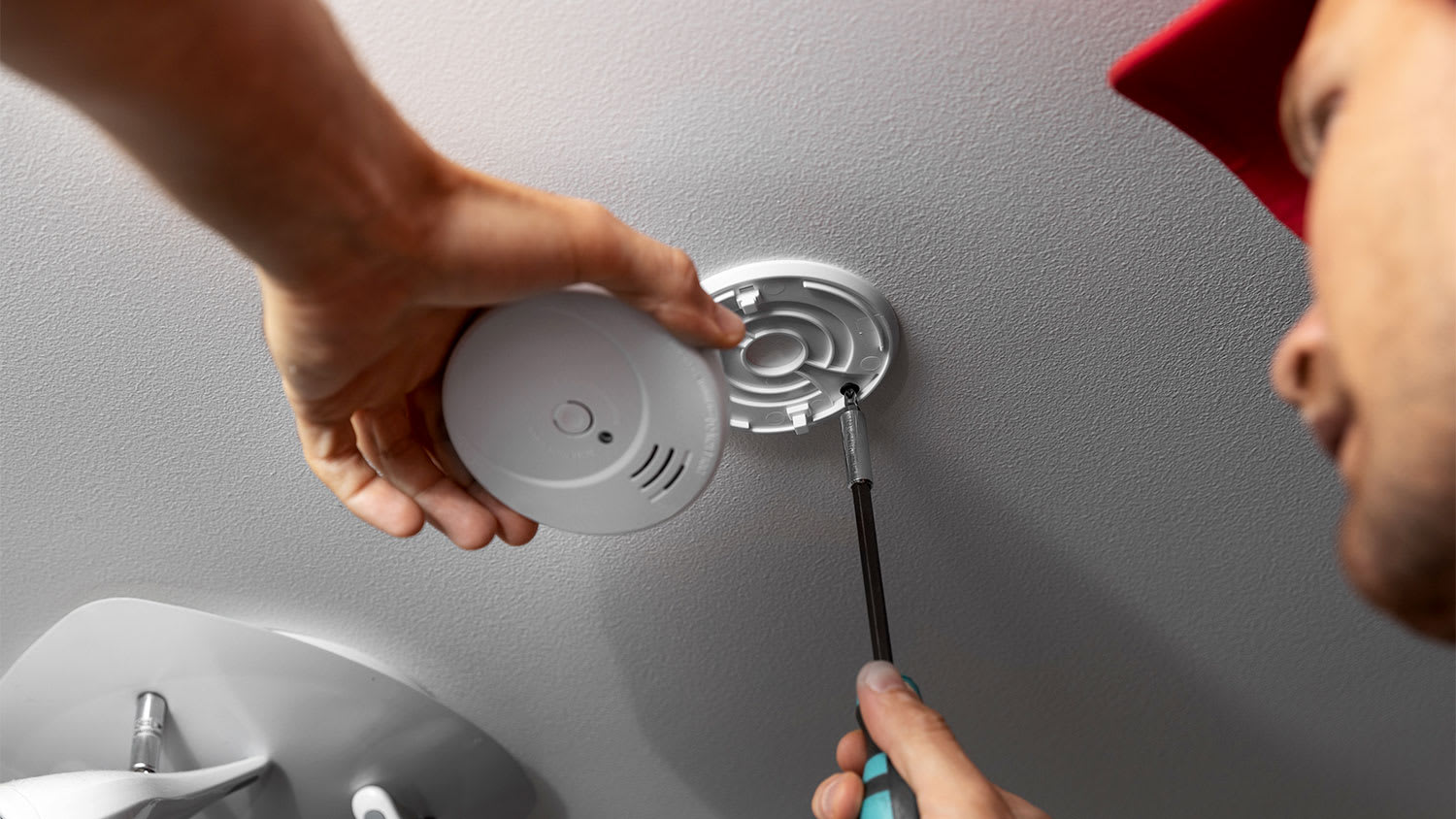 Man checking smoke detector