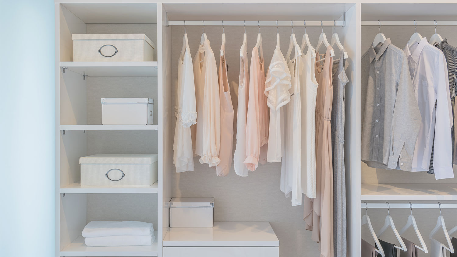 Tops and dresses hanging in a white closet